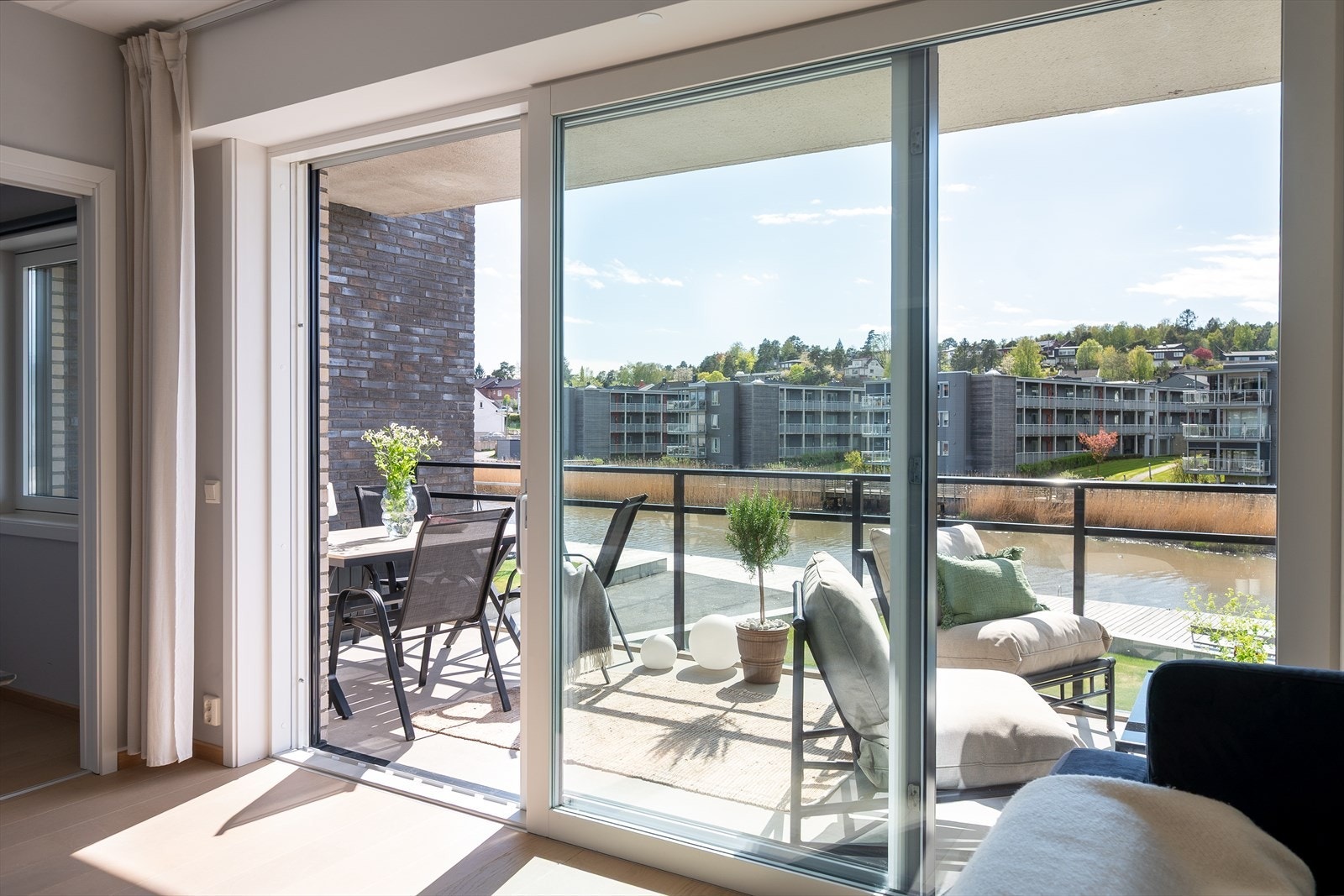 Vinduet og de doble skyvedørene ut til balkongen fyller nesten hele stuens endeveggen, og de bader hele rommet i lys og utsikt. Galleribilde