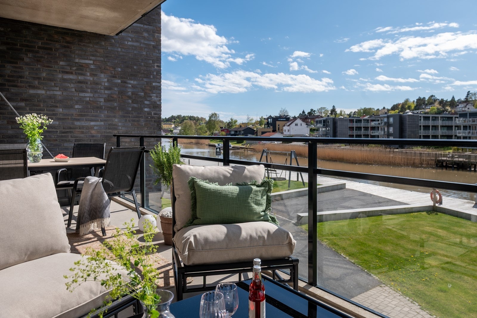 Ute på balkongen sitter du ofte i kveldssolen og beundrer utsikten, mens en båt putrer forbi og sivene på den andre bredden vaier i brisen. Regner det, sitter du tørt under overbygget. Materialer som glass og teglstein understreker det solide. Galleribilde