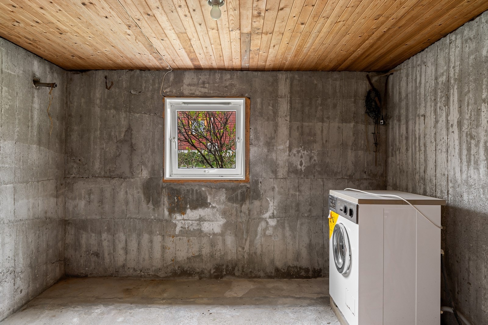 Vaskekjeller med opplegg for vaskemaskin og sluk i gulvet. Galleribilde