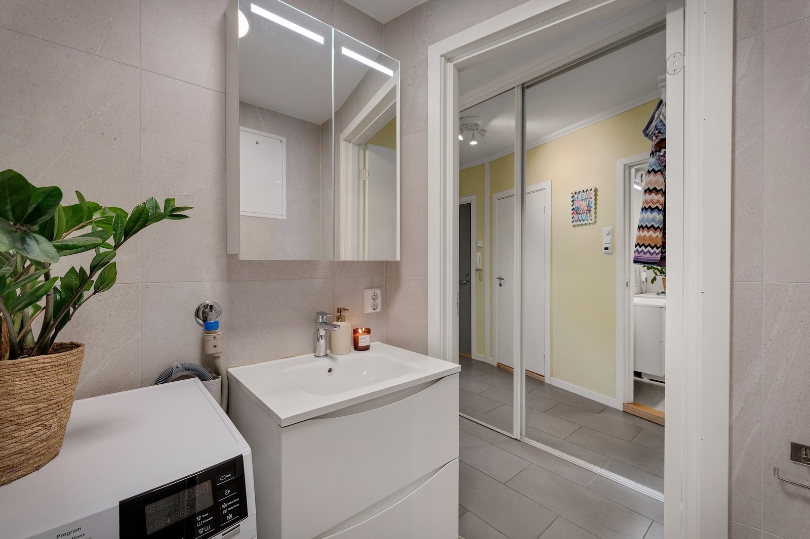 - Badet inneholder innfellbare dusjdører i glass, innebygd sisterne, benkeskap med servant og opplegg for vaskemaskin - Galleribilde