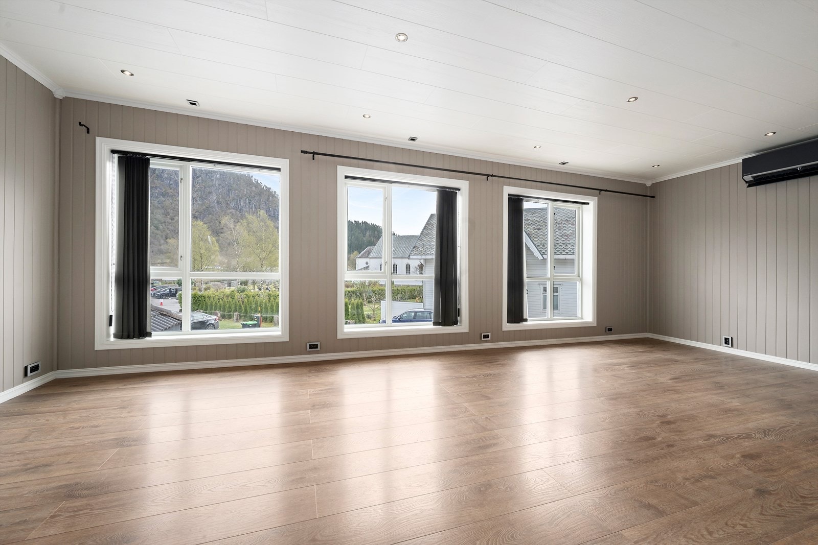 Romslig stue med store vindusflater Galleribilde
