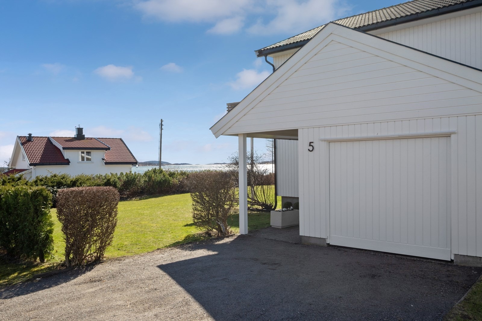 Parkering i garasje og gårdsplass. Det er montert elbillader. Galleribilde