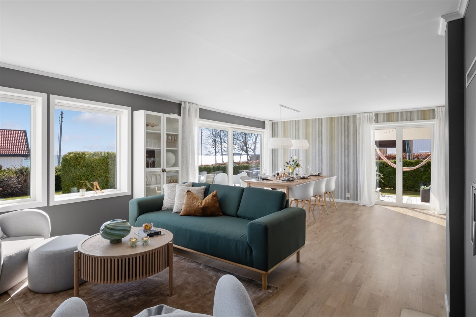 Stuen er et imponerende rom som kombinerer stilren eleganse med funksjonelle kvaliteter med laminat på gulv og slette vegger malt i et lun og trendy fargepallett. Galleribilde