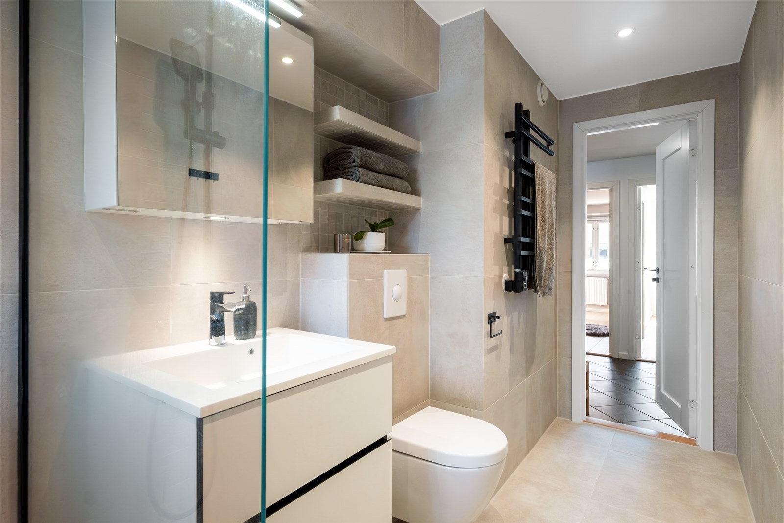 Badet er utstyrt med veggmontert wc, servant og speilskap med gode oppbevaringsmuligheter - naturlig avtrekk. Galleribilde