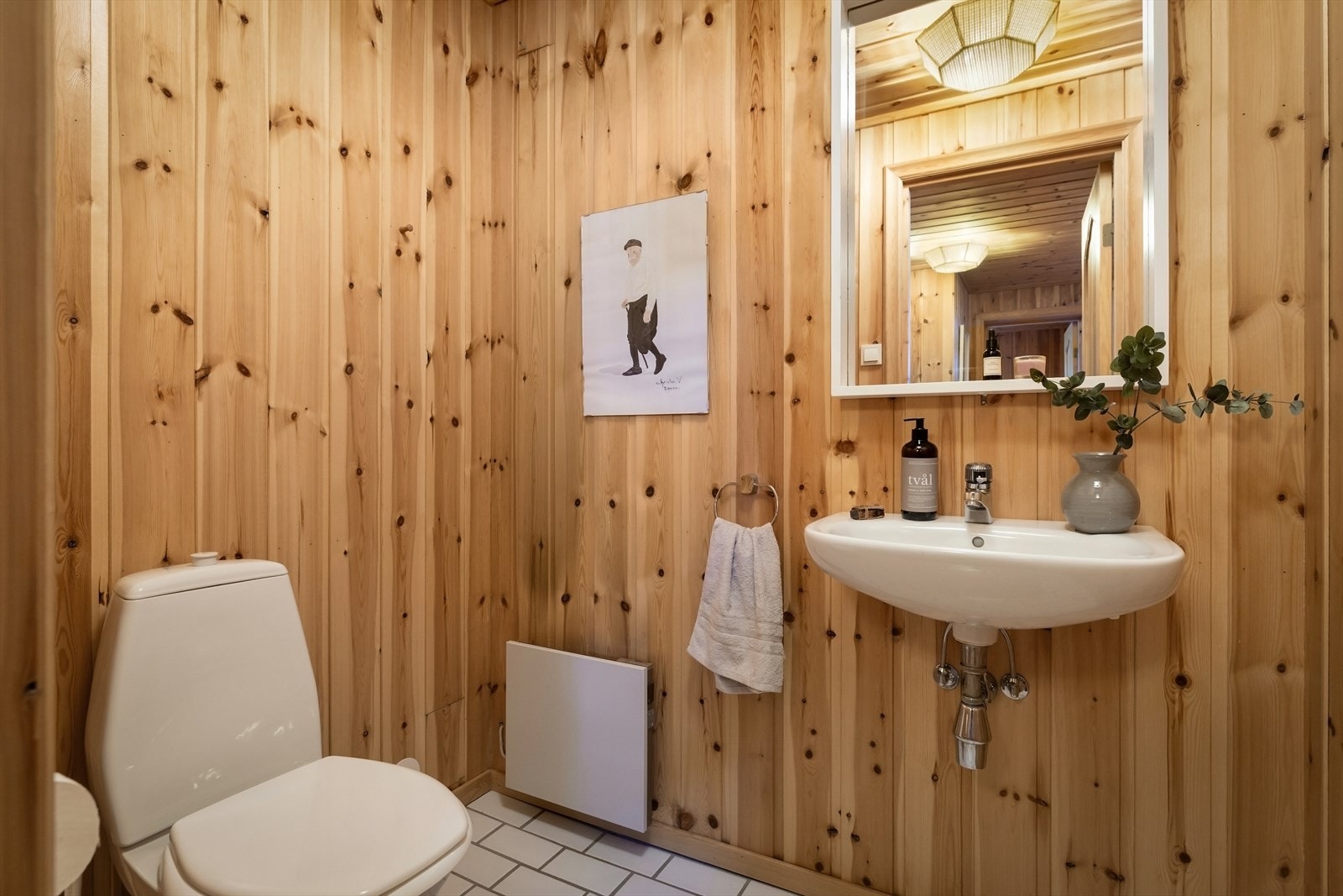 Separat toalettrom med fliser på gulv og trepanel i himling. Galleribilde