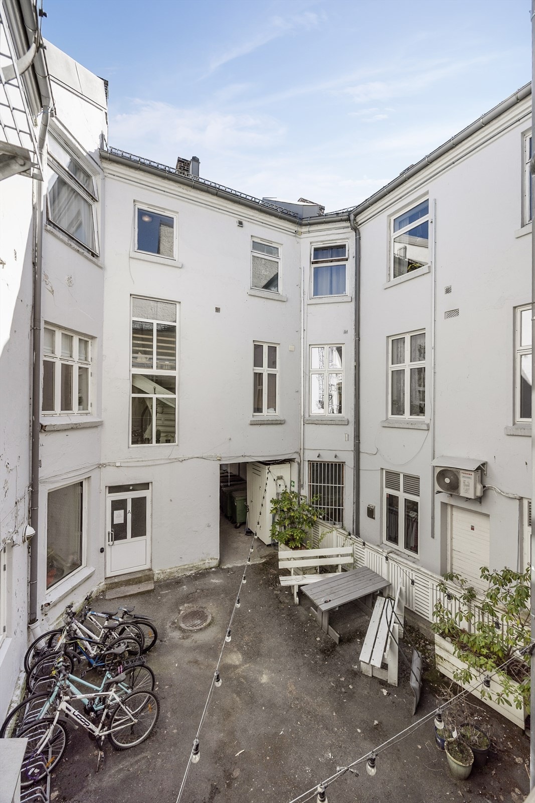 Den sjarmerende og asfalterte bakgården er felles for beboerne, med sittegrupper og sykkelparkering. Galleribilde