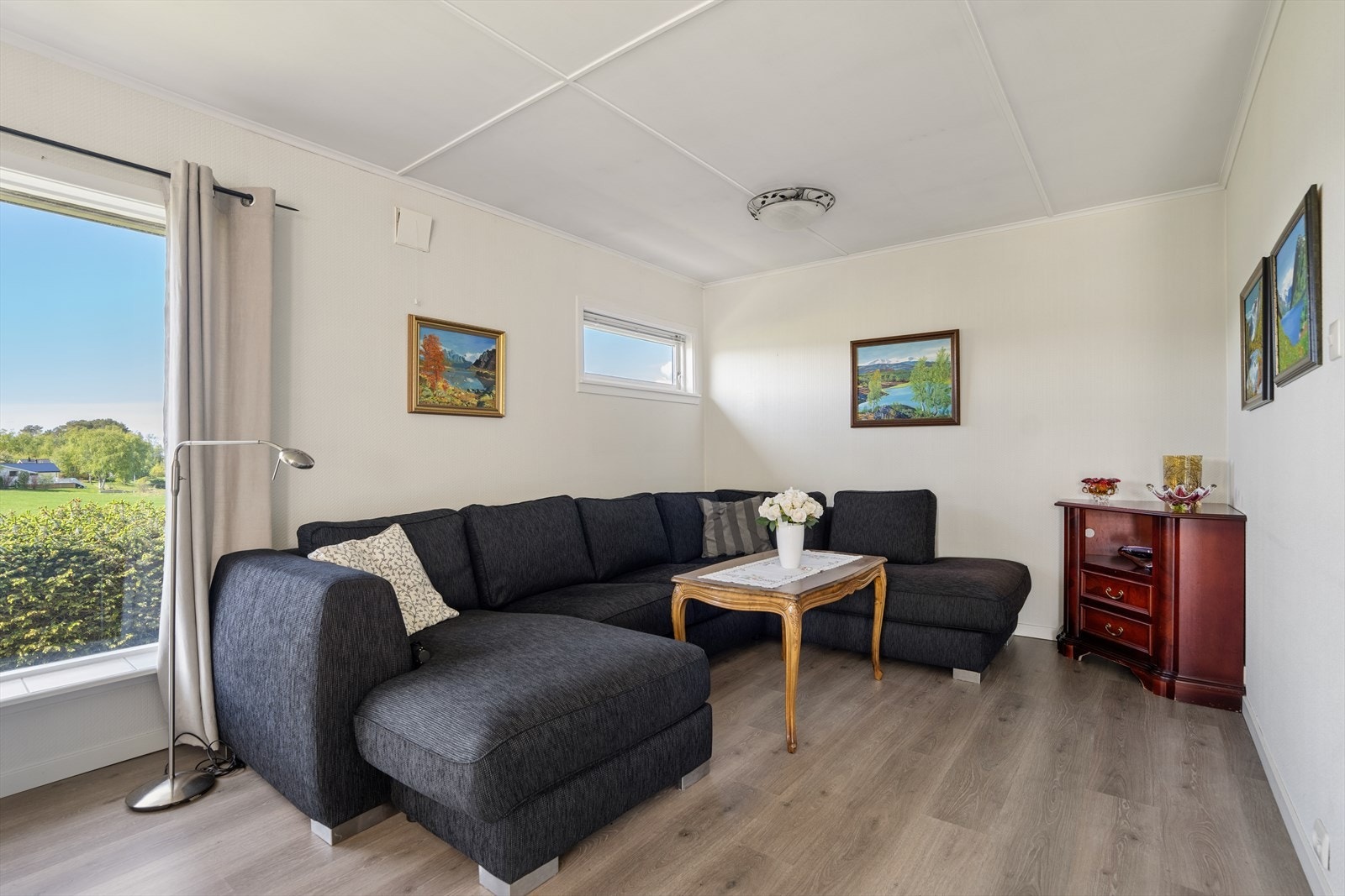 Romslig stue med plass til en stor sofagruppe. Galleribilde
