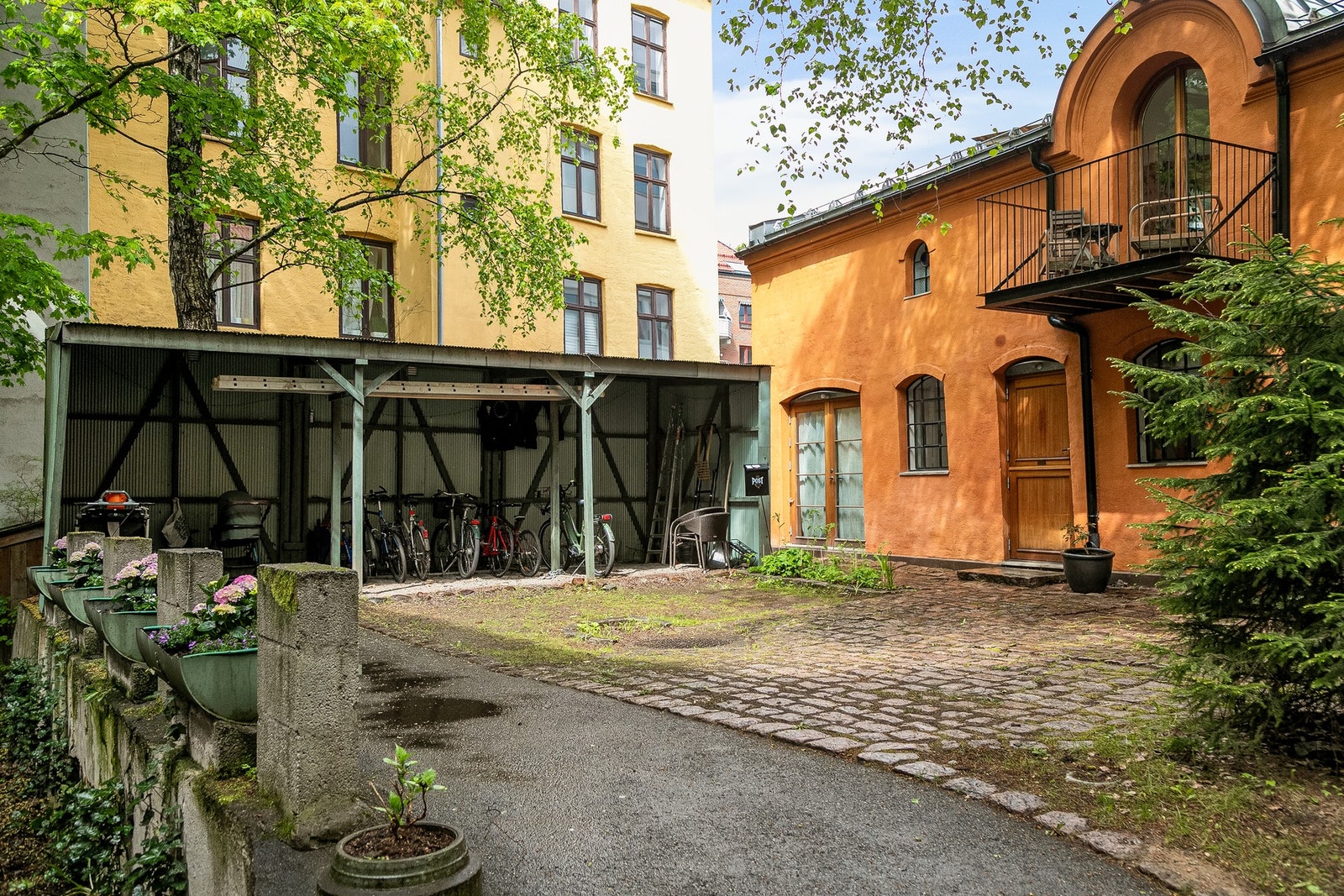 Felles avlåst gårdsrom opparbeidet med sittegruppe, terrasseplatting, plen og variert beplantning. Galleribilde