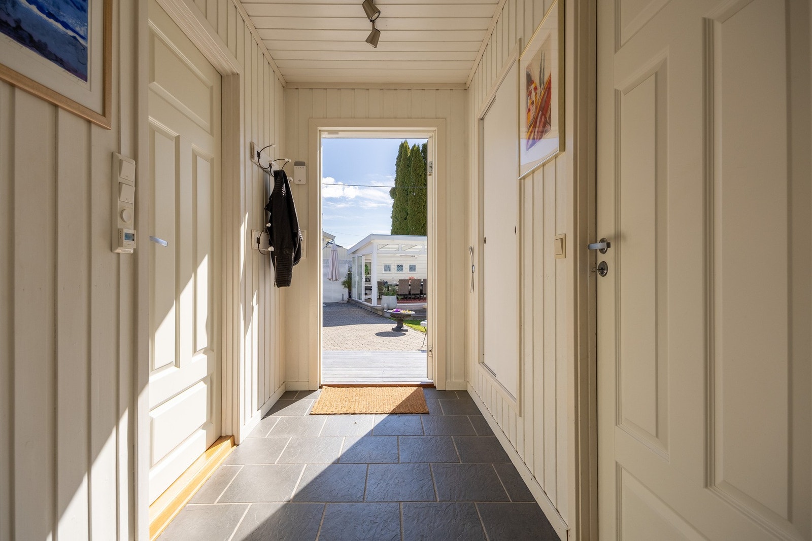 Her ønskes du velkommen inn i en flislagt entré med direkte utgang til gårdsplassen. Galleribilde