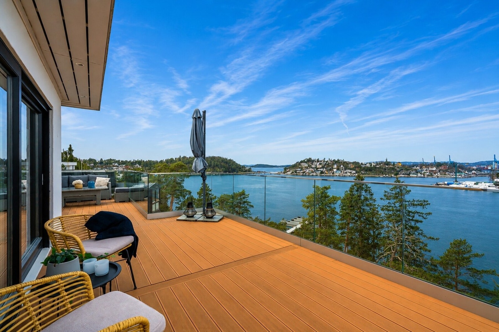 Utenfor stue og spisestue er det vestvendt terrasse med moderne rekkverk i glass og aluminium, samt vedlikeholdsfrie terrassebord (Noe snø er fjernet fra bildet ved bruk av AI) Galleribilde