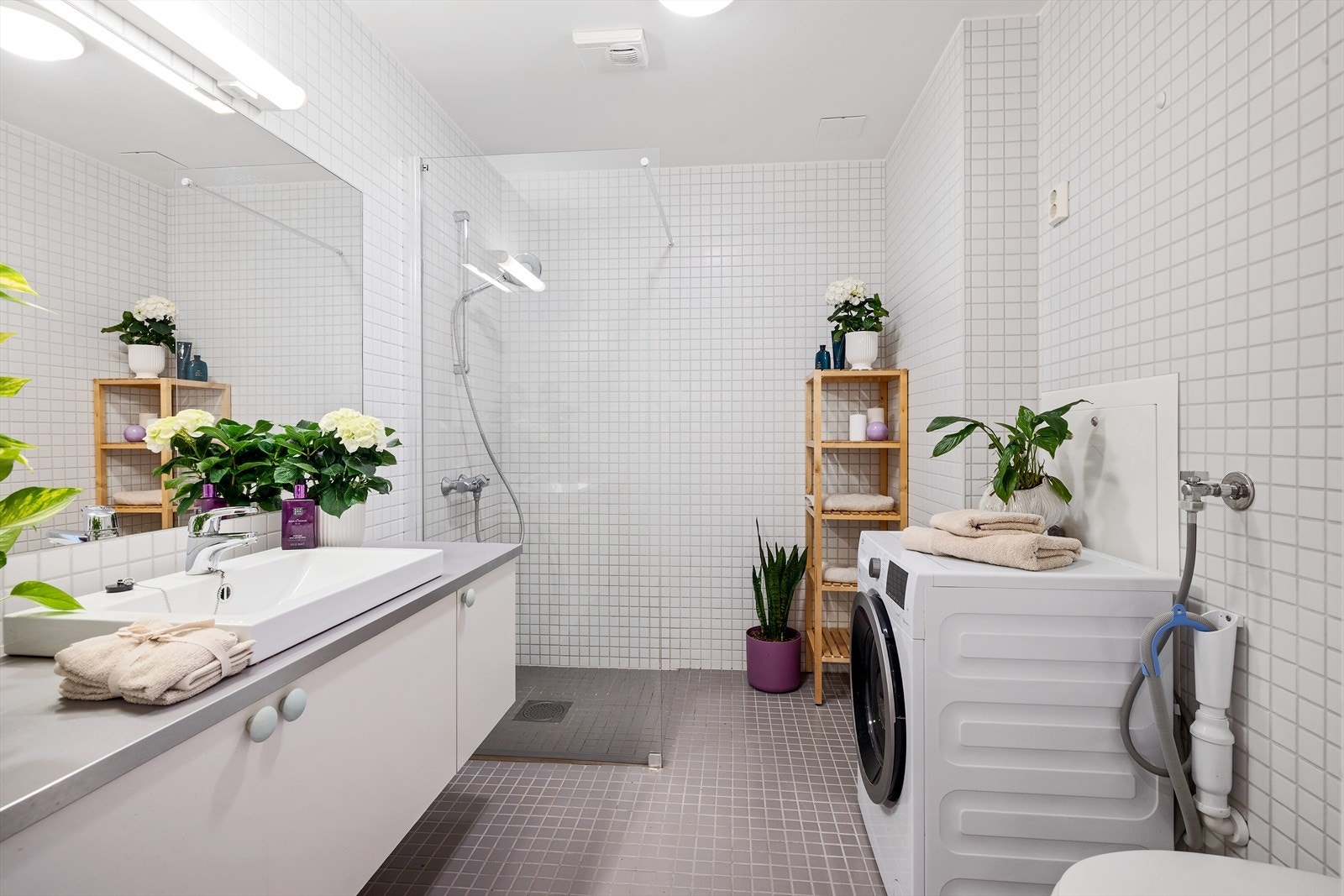 Badet har flislagte overflater, servantinnredning og mekanisk avtrekk Galleribilde