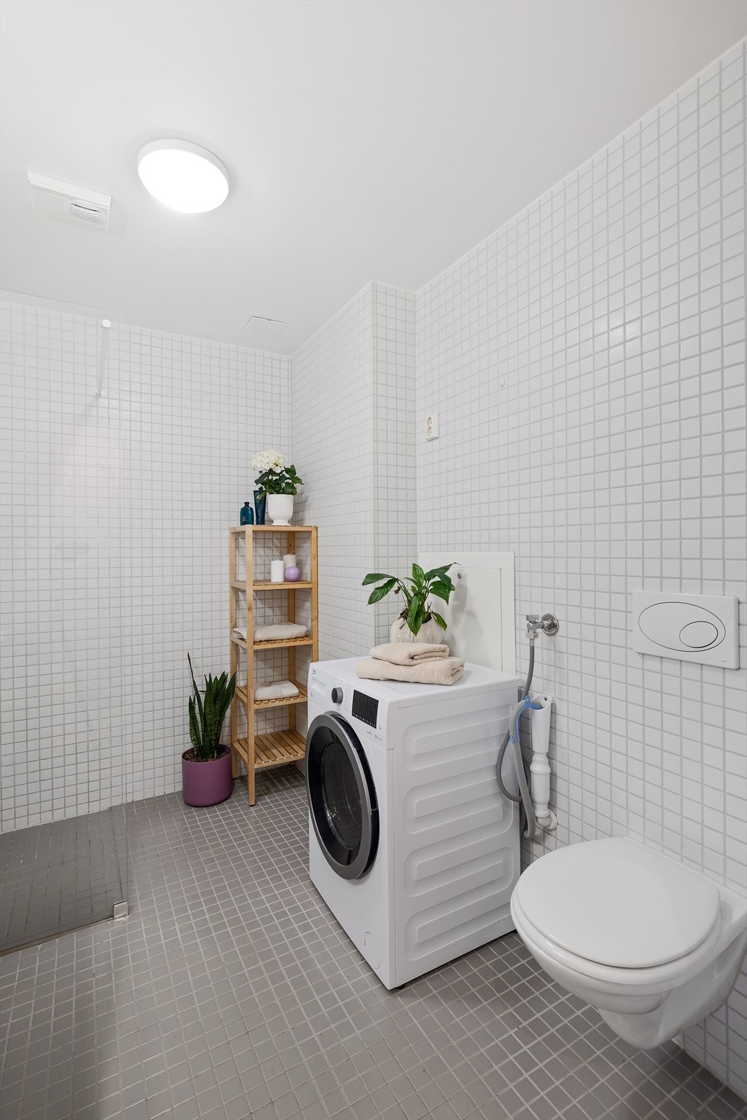 Badet er utstyrt med veggmontert toalett, dusjløsning og vannbåren gulvvarme Galleribilde
