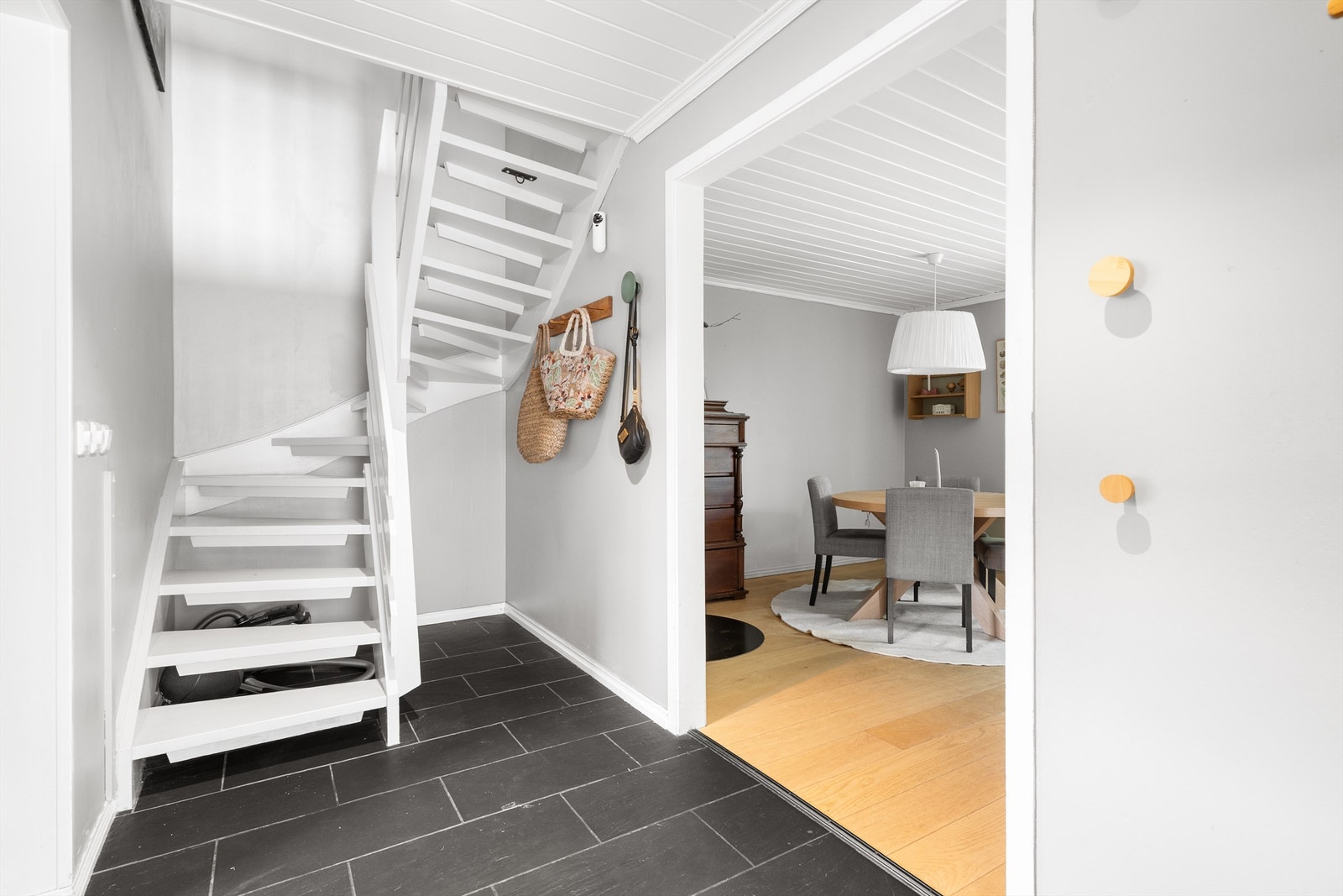 Entréen har flislagt gulv med varmekabler og en malt tretrapp som fører opp til loftsetasjen. Galleribilde