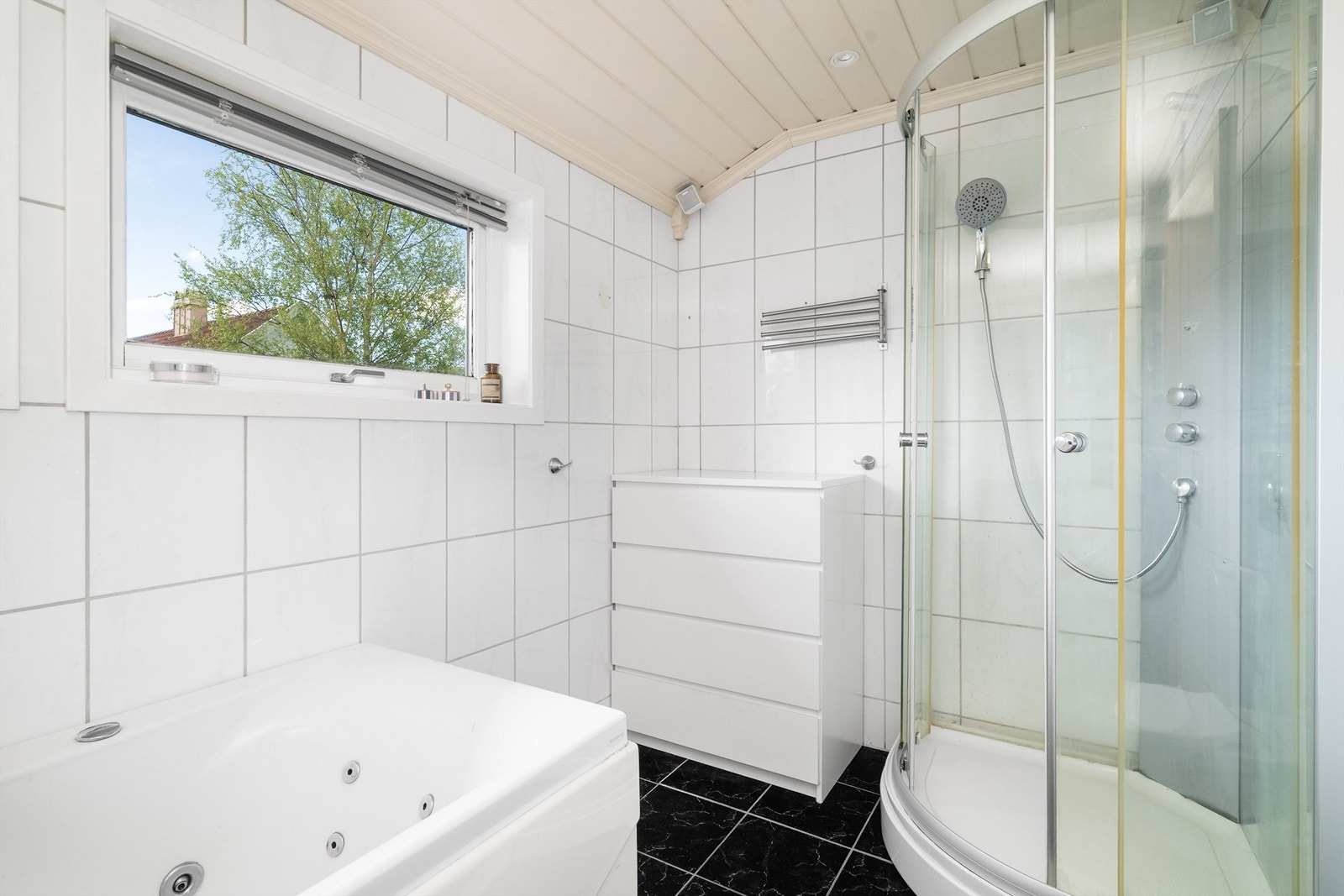 Badet er utstyrt med både badekar og dusjkabinett, og har flislagt gulv med elektriske varmekabler. Galleribilde