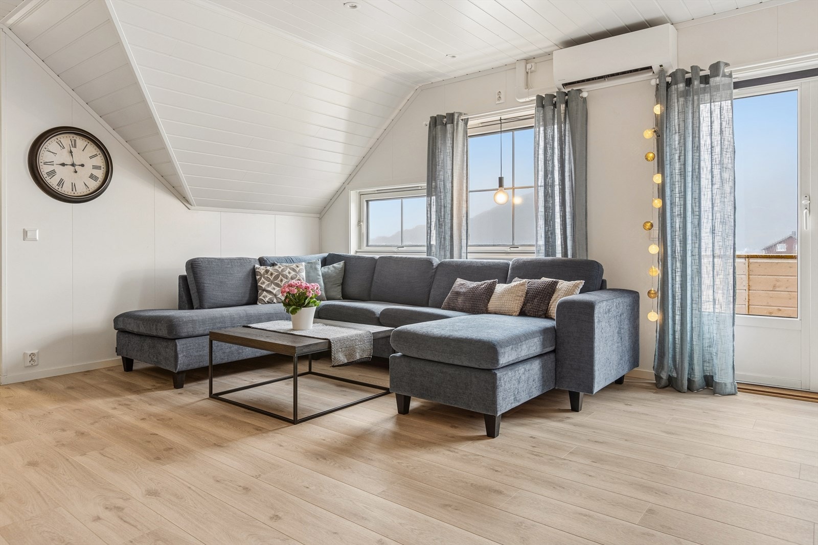 Stor og luftig stue med skråtak og gode møbleringsmuligheter, perfekt for både avslapning og sosiale sammenkomster. Galleribilde
