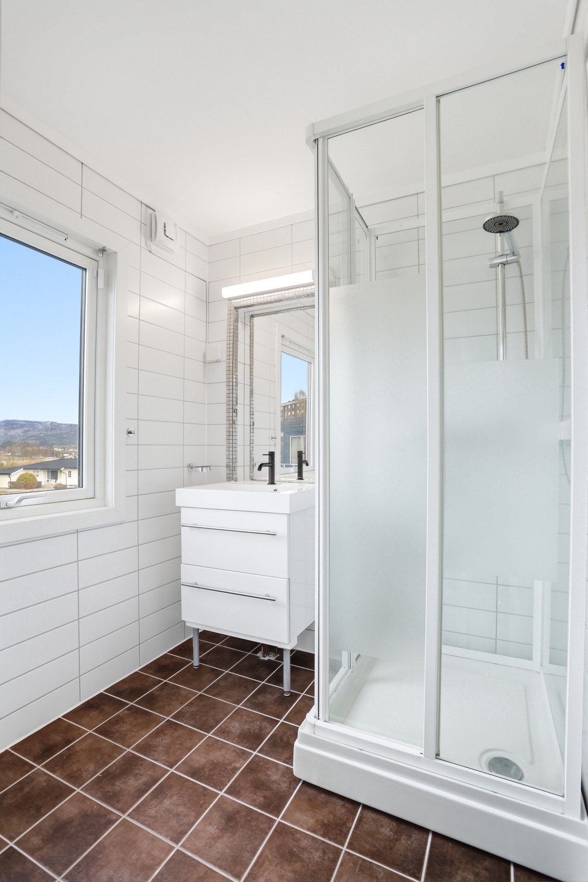 Badet i hoveddelen ligger i nærhet av soverom og har flislagt gulv med varmekabler, våtromsplater på vegg, montert dusjkabinett og gulvstående toalett. Galleribilde