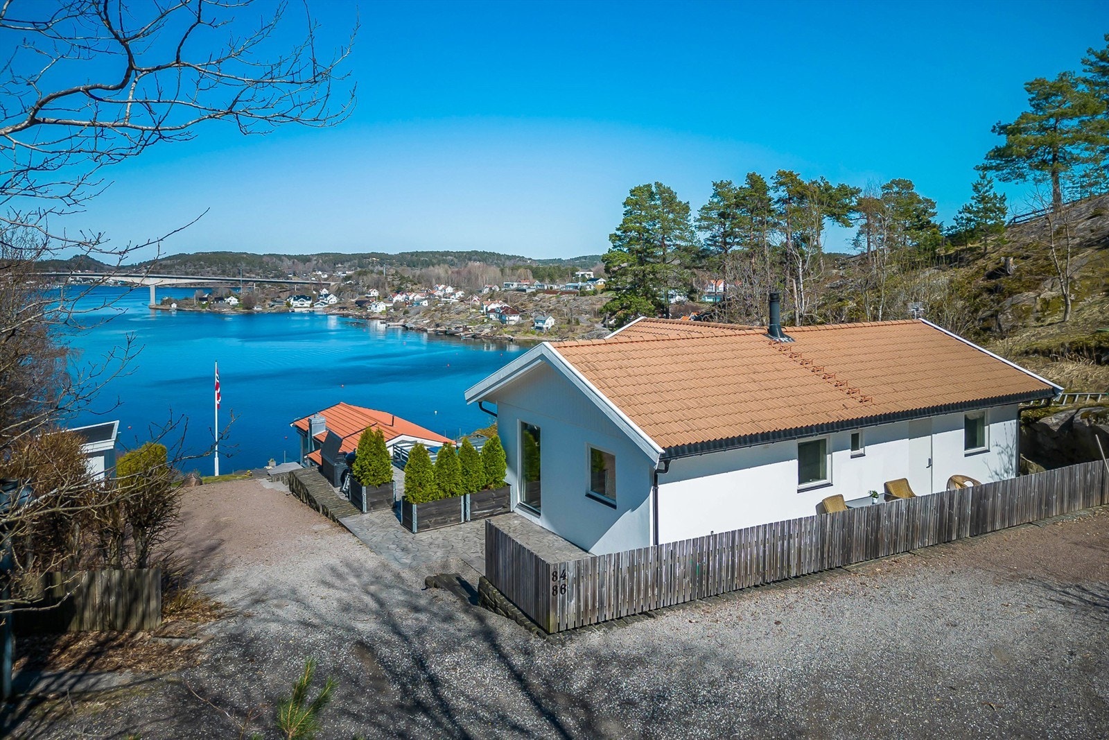 Rødnesveien 84 (gnr. 208, bnr. 176) har en eiet tomt på ca. 715,2 kvm. Skrånede tomt med noe blottet fjell opparbeidet med gruset innkjøring og gårdsplass, platting rundt huset, forstøttningsmurer, plenarealer og diverse beplantning. Galleribilde