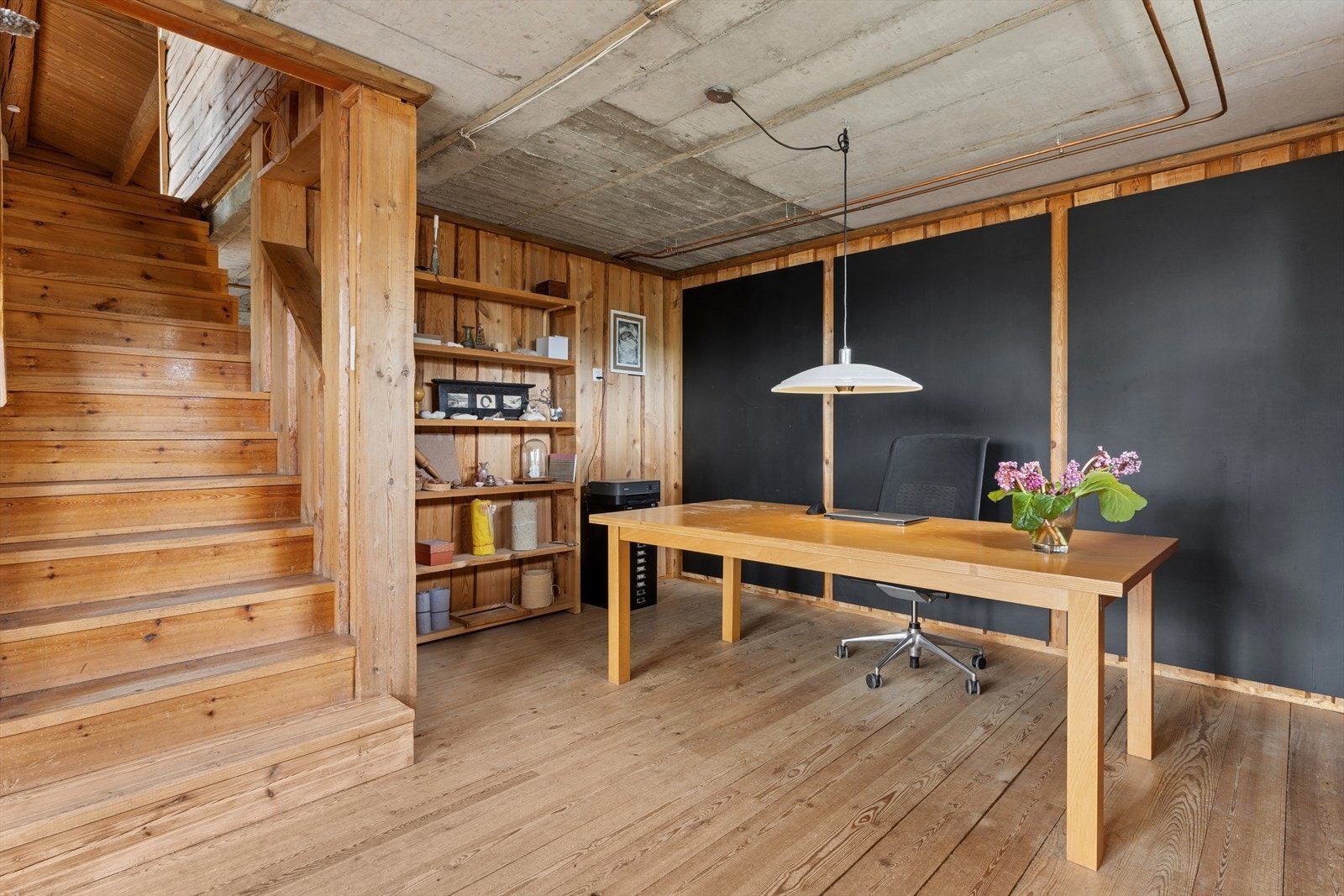 Romslig kontor/spisestue i kjelleretasjen, med synlig betongdekke i taket og furugulv. Galleribilde