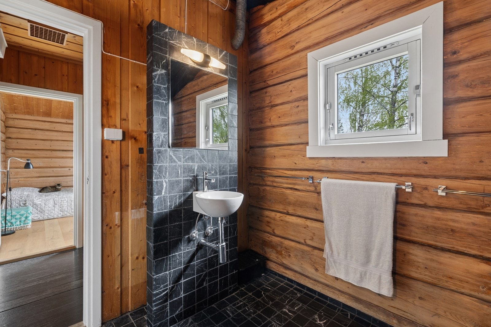 Badet i første etasje kombinerer tømmervegger med moderne fliser og har elektrisk gulvvarme. Galleribilde