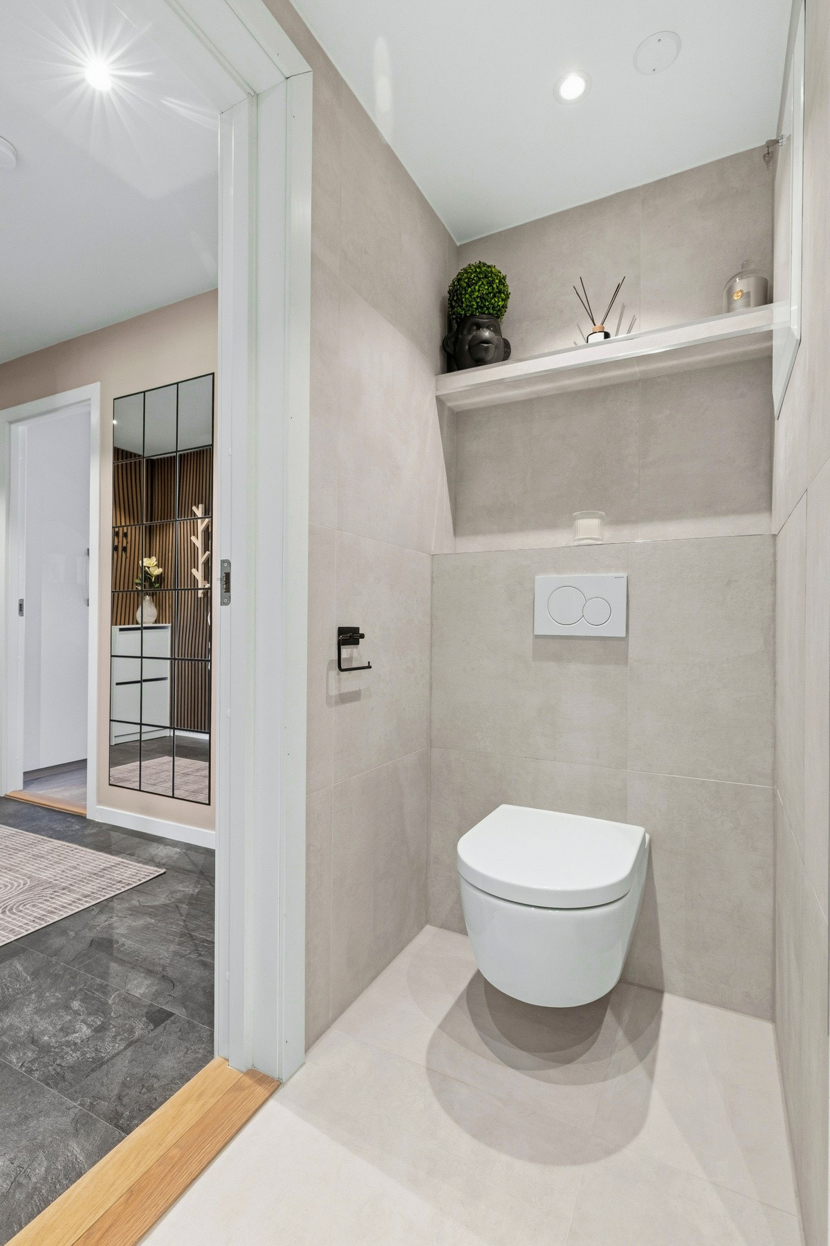Badet er utstyrt med servant, klosett, dusj på gulv og opplegg for vaskemaskin Galleribilde