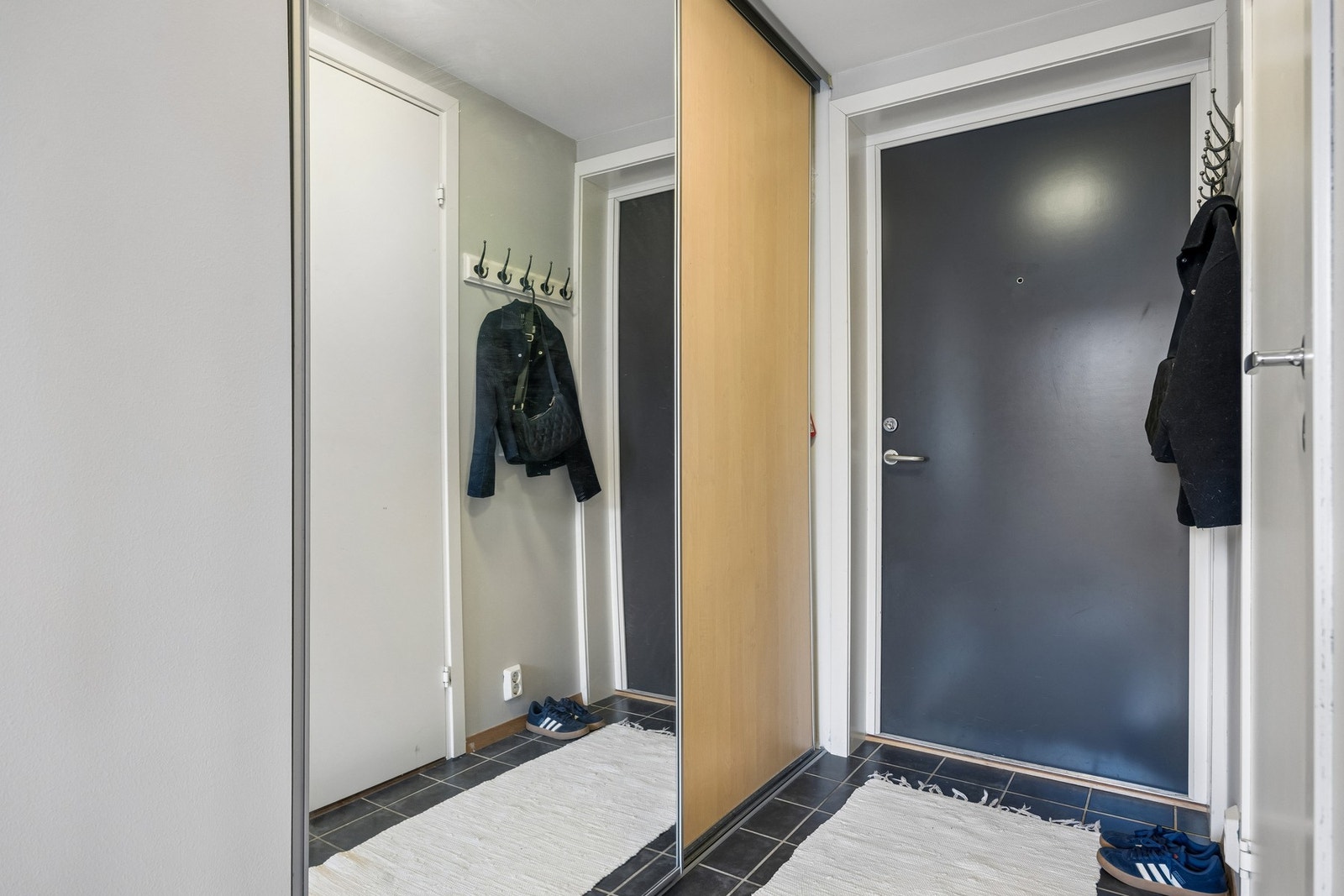 Innbydende entré med praktisk skyvedørsgarderobe for oppbevaring av yttertøy. Galleribilde