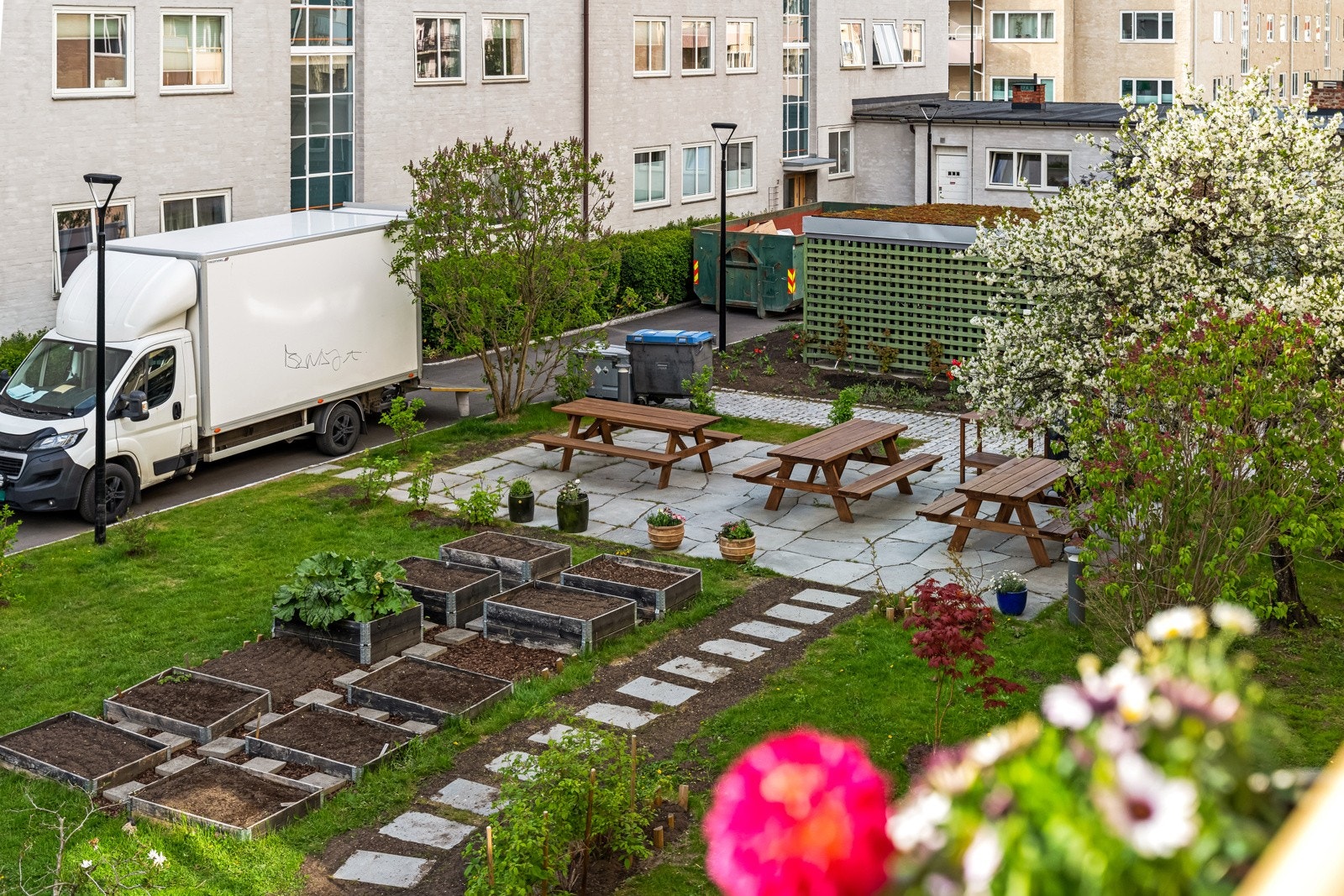 Pent opparbeidet bakgård med sitteplasser og små parseller til beplantning. Galleribilde