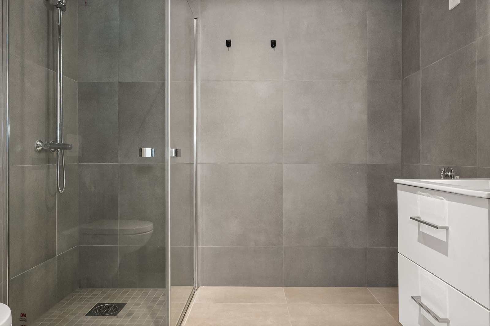 Romslig dusjhjørne med innfellbare glassdører. Det er også opplegg for vaskemaskin på badet. Galleribilde