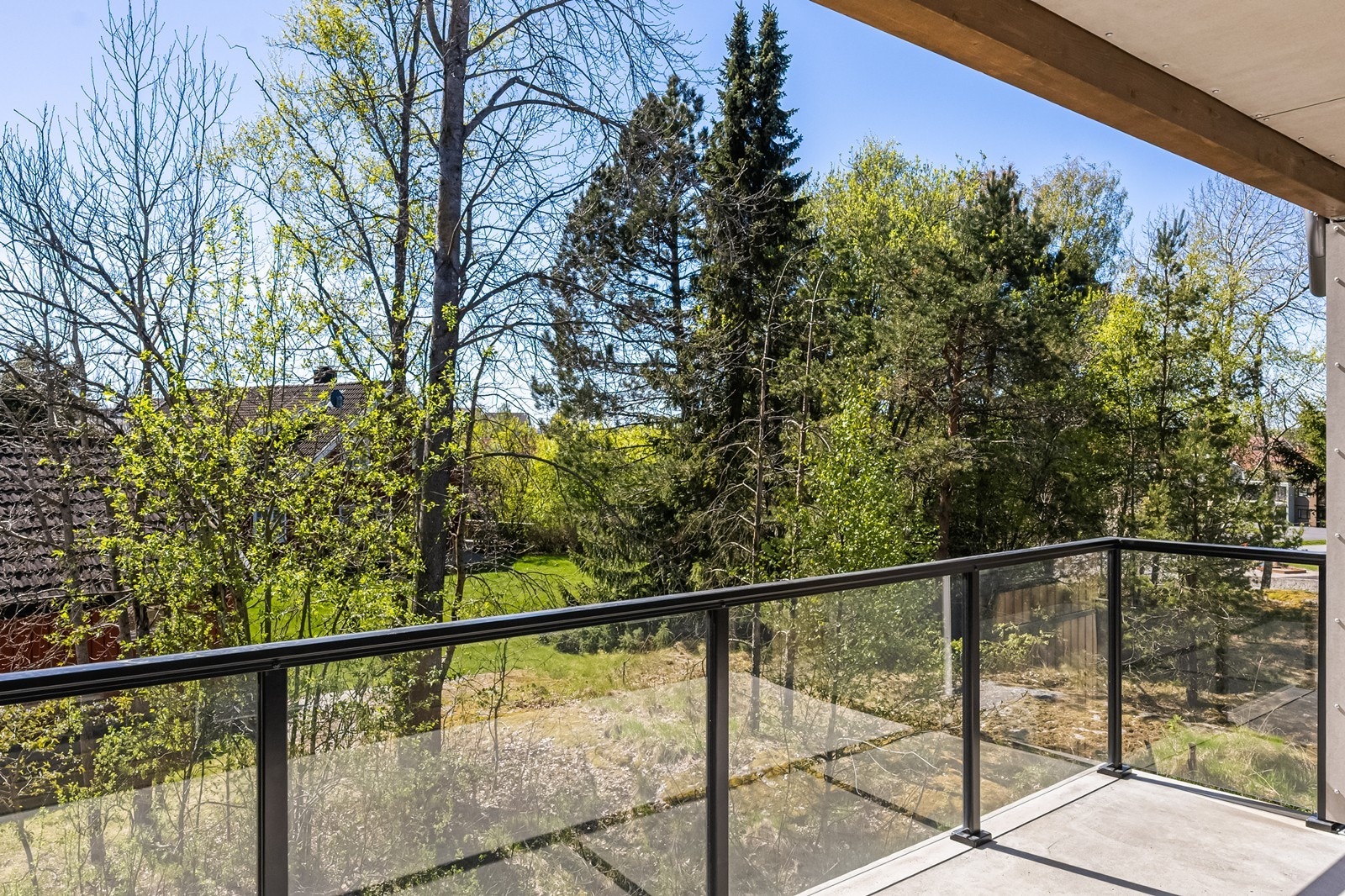 Balkongen har rekkverk i stål og glass, som gir en åpen og trygg ramme rundt uteplassen. Galleribilde