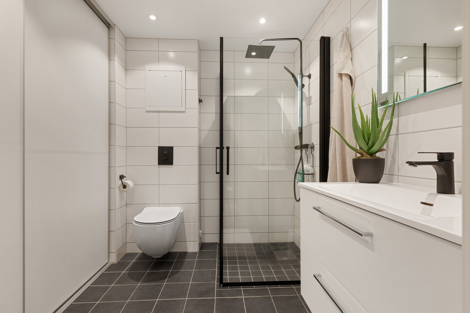 Praktisk skyvedørsgarderobe skjuler opplegg for vaskemaskin og tørketrommel og bidrar til et ryddig og helhetlig uttrykk. Galleribilde