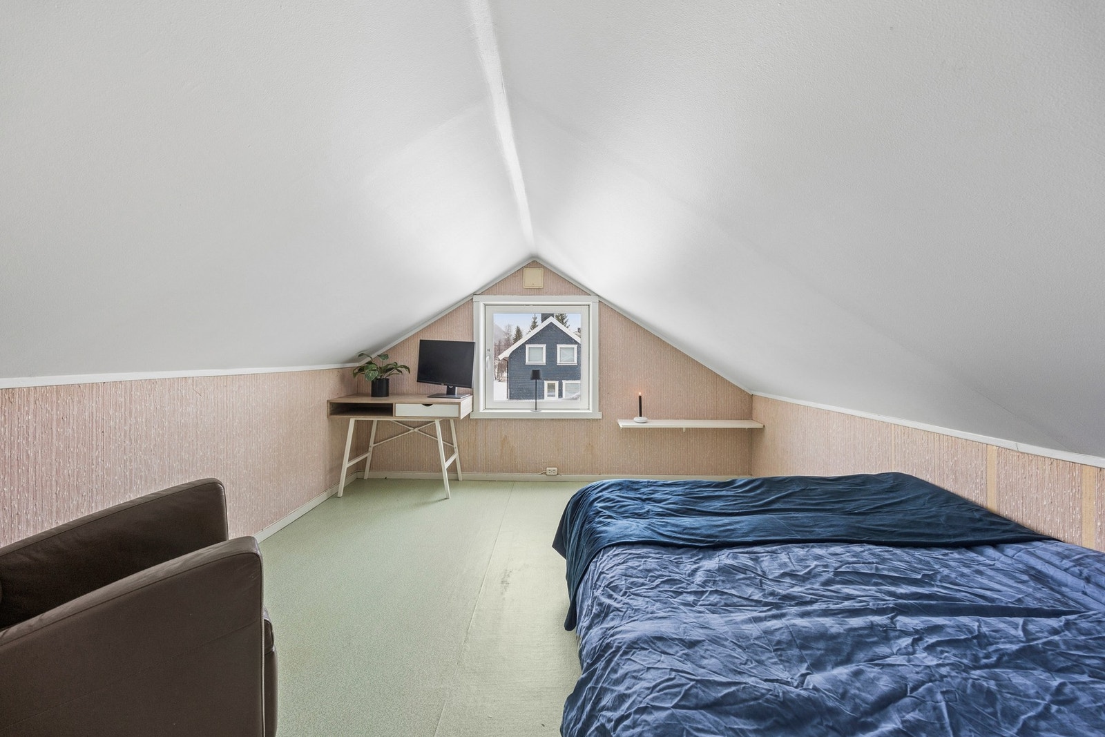 Loftsrommet har skråtak og et vindu som gir dagslys. Galleribilde