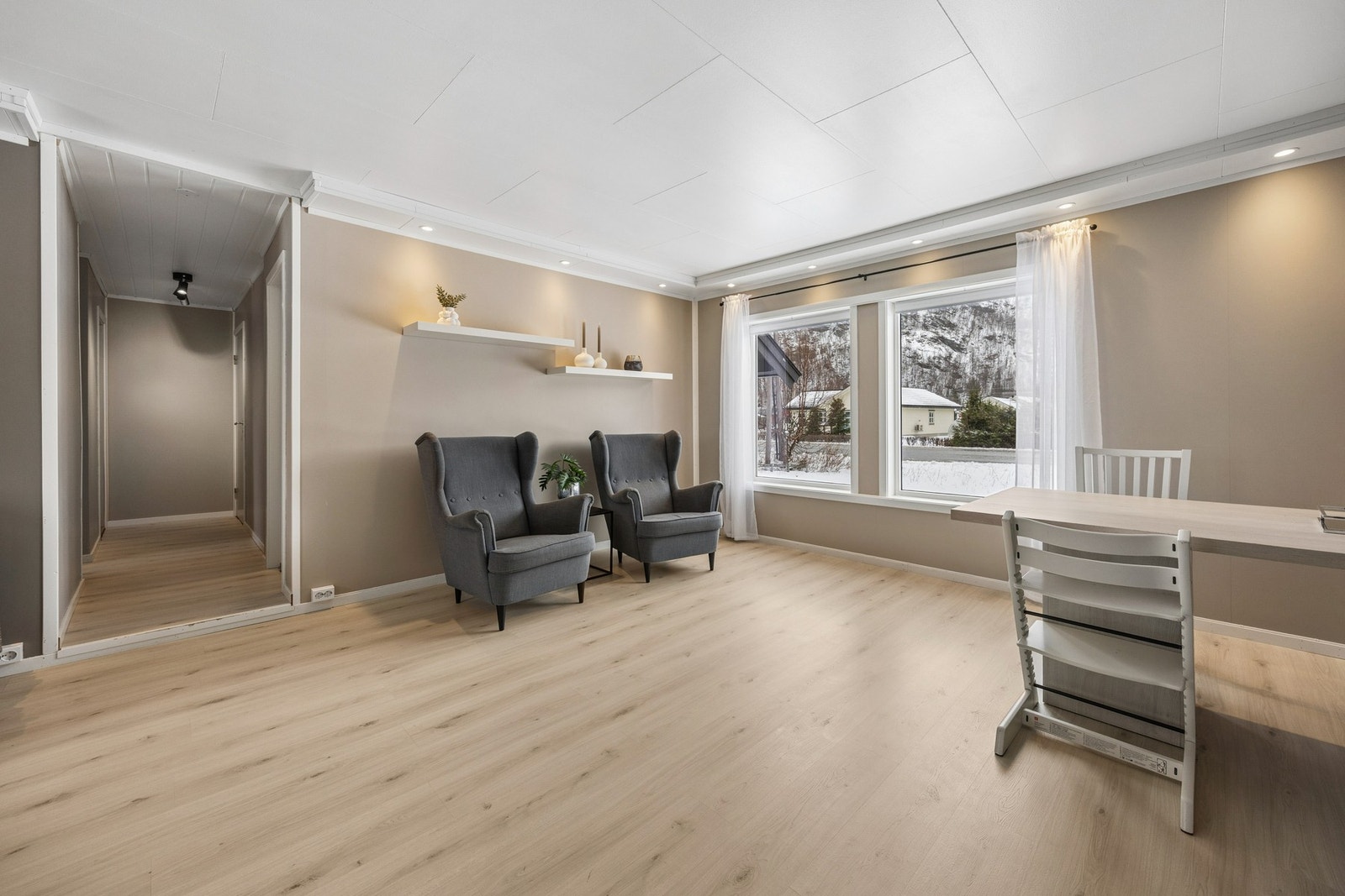 Store vindusflater gir rikelig med naturlig lys inn i stuen. Galleribilde