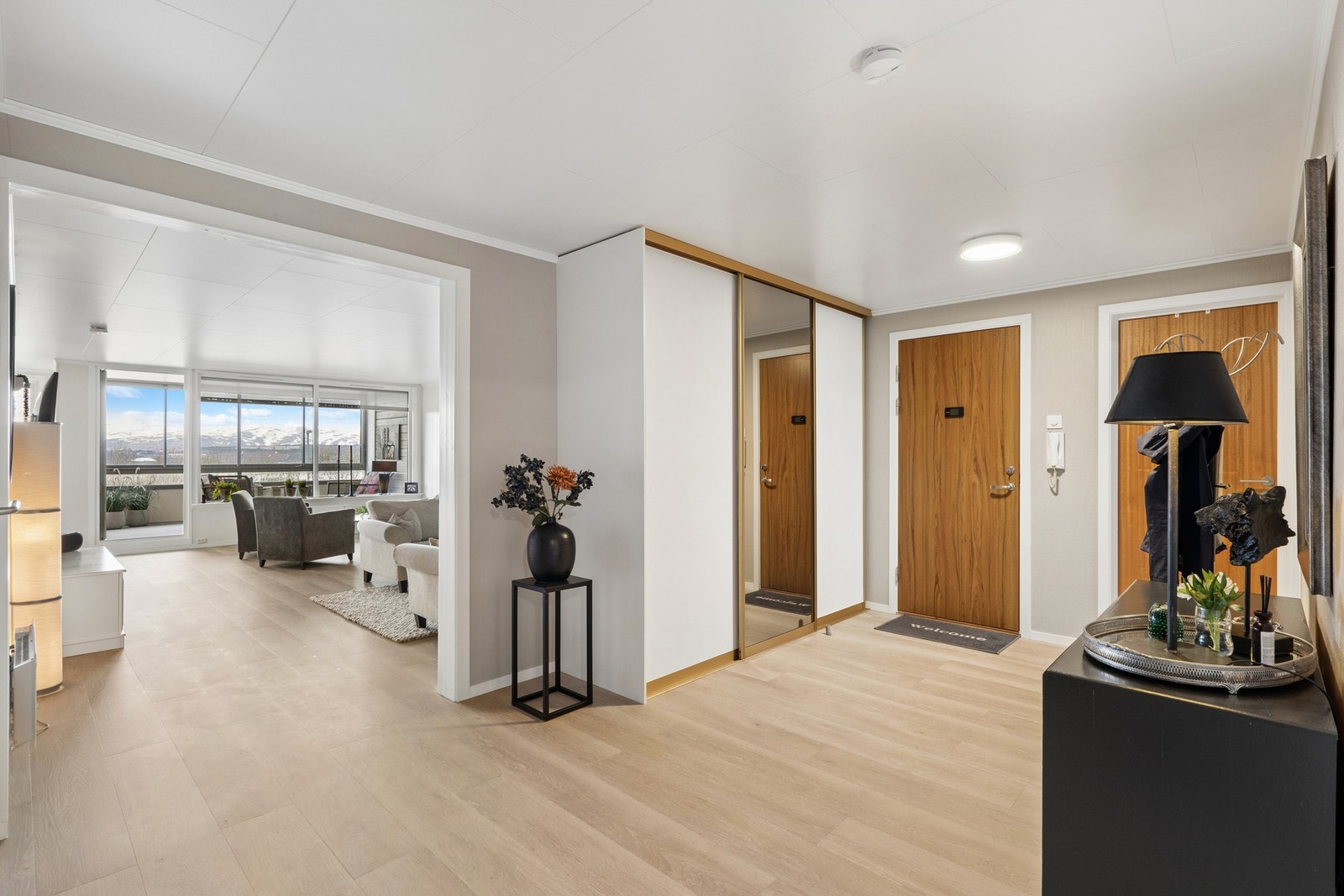 Entréen har nyere laminatgulv og en praktisk skyvedørsgarderobe for effektiv oppbevaring. Galleribilde