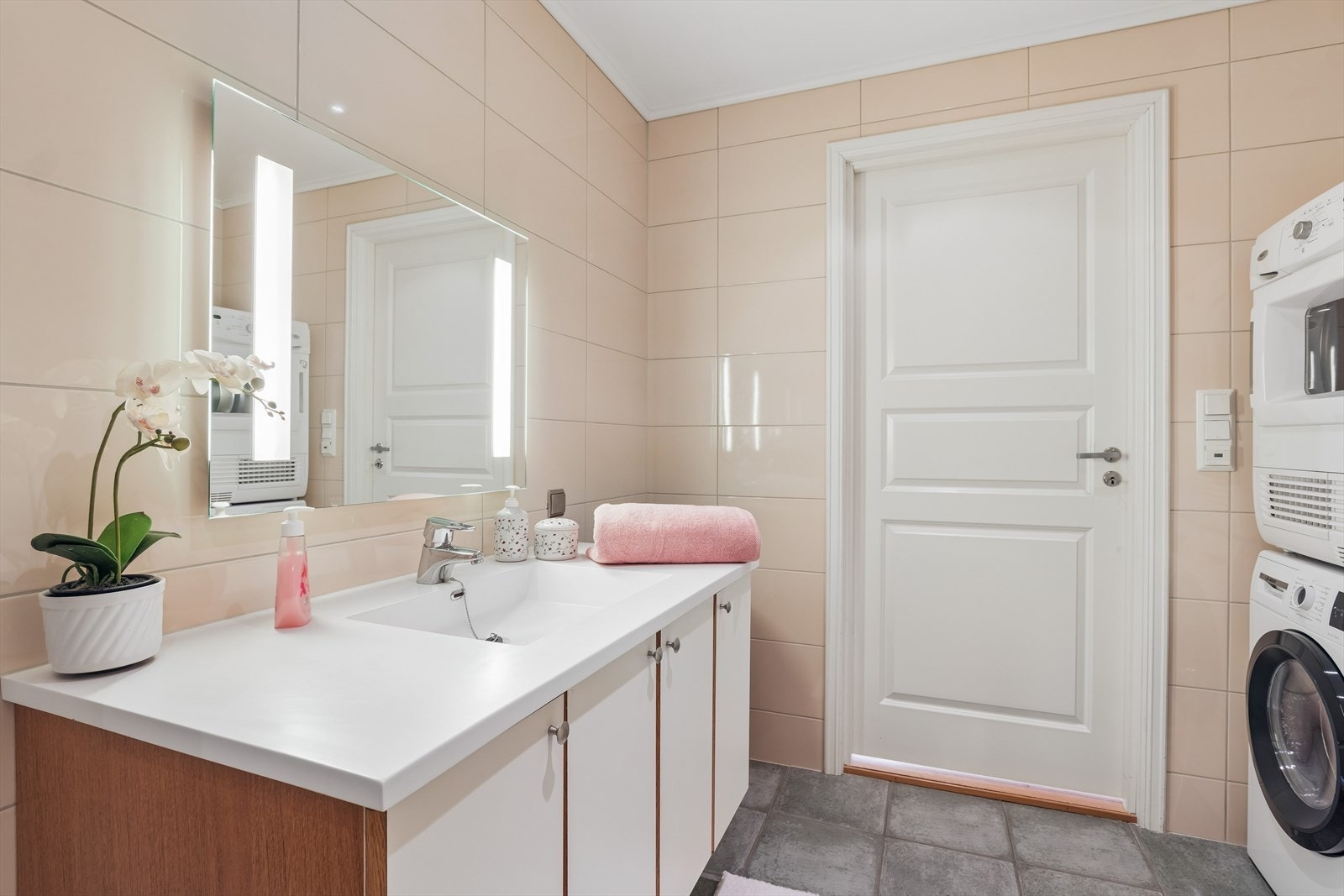 Rommet er innredet med dusjkabinett, wc, servantskap og speil med integrert belysning. Opplegg for vaskemaskin. Galleribilde