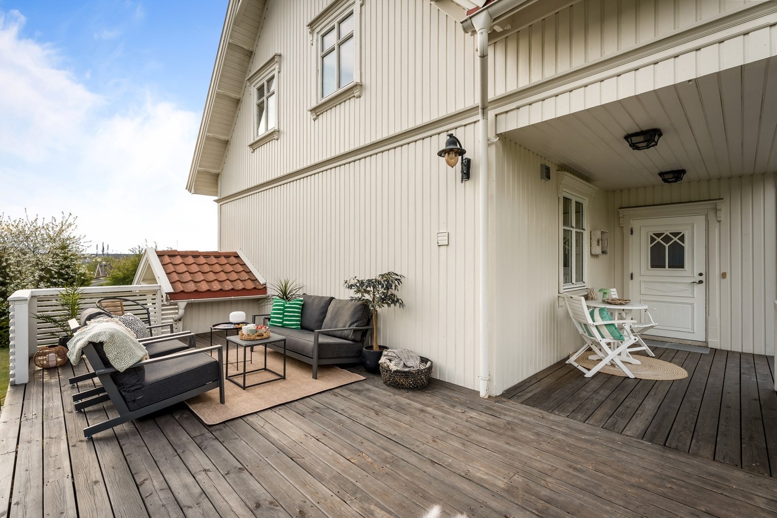 Det overbygde inngangspartiet har plass til en liten sittegruppe. Galleribilde
