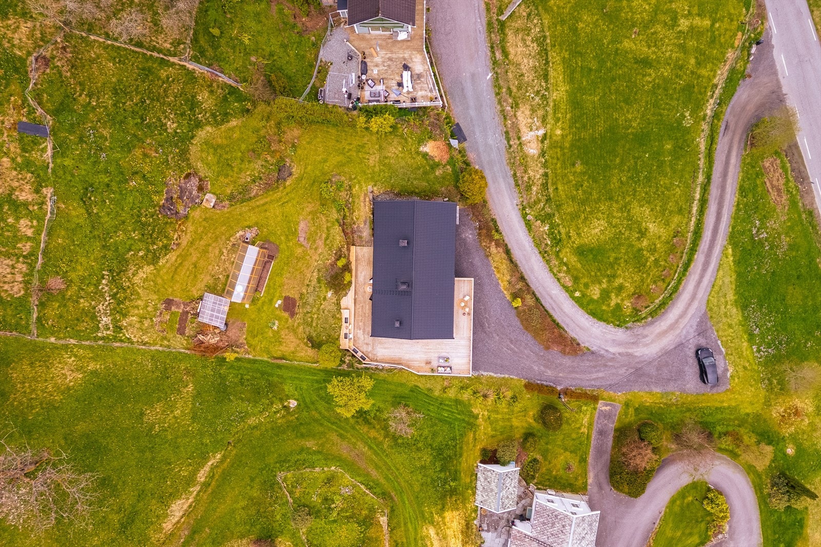 Ikke bare stor bolig, med nyere terrasse og carport. En eier drivhuset og bakken oppover Galleribilde