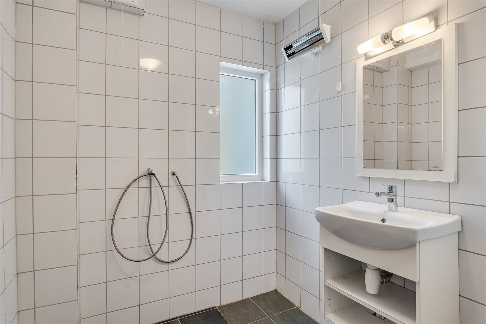 Badet inneholder innredning med servant og toalett Galleribilde