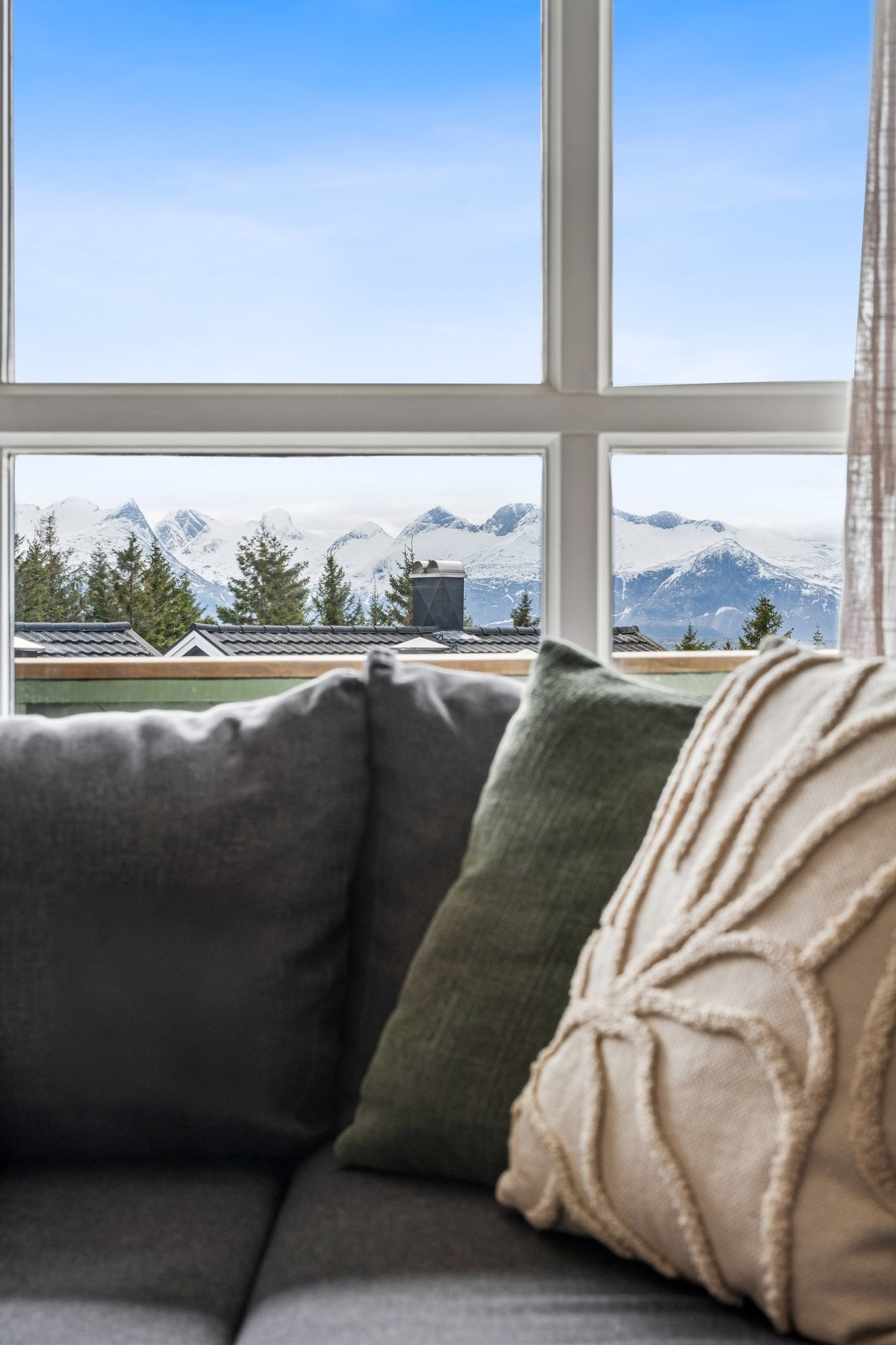 Utsikten mot fjellene kan også nytes fra sofakroken. Galleribilde