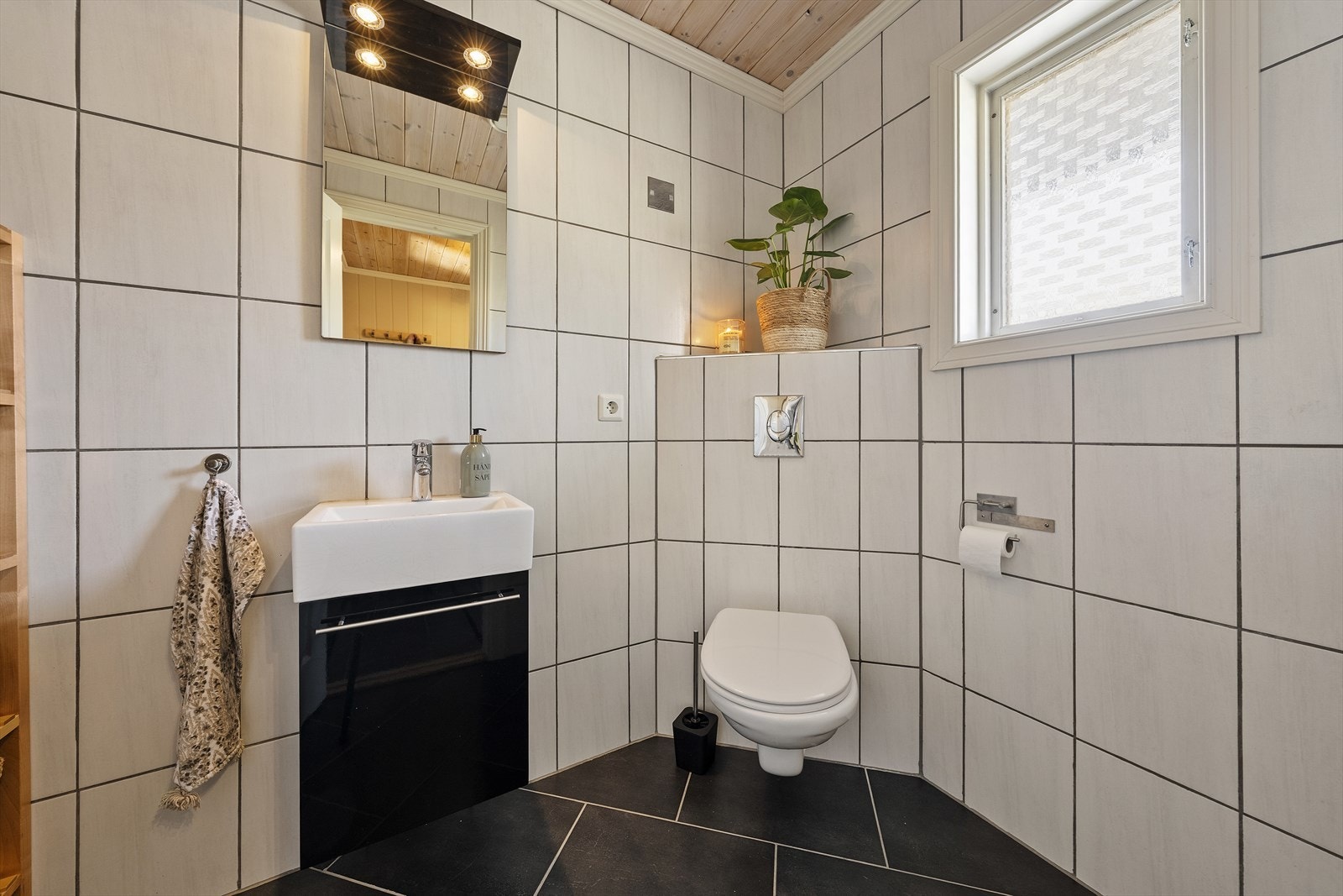 I tillegg til badet, er det et separat toalettrom med servant over skuffeinnredning og vegghengt toalett Galleribilde