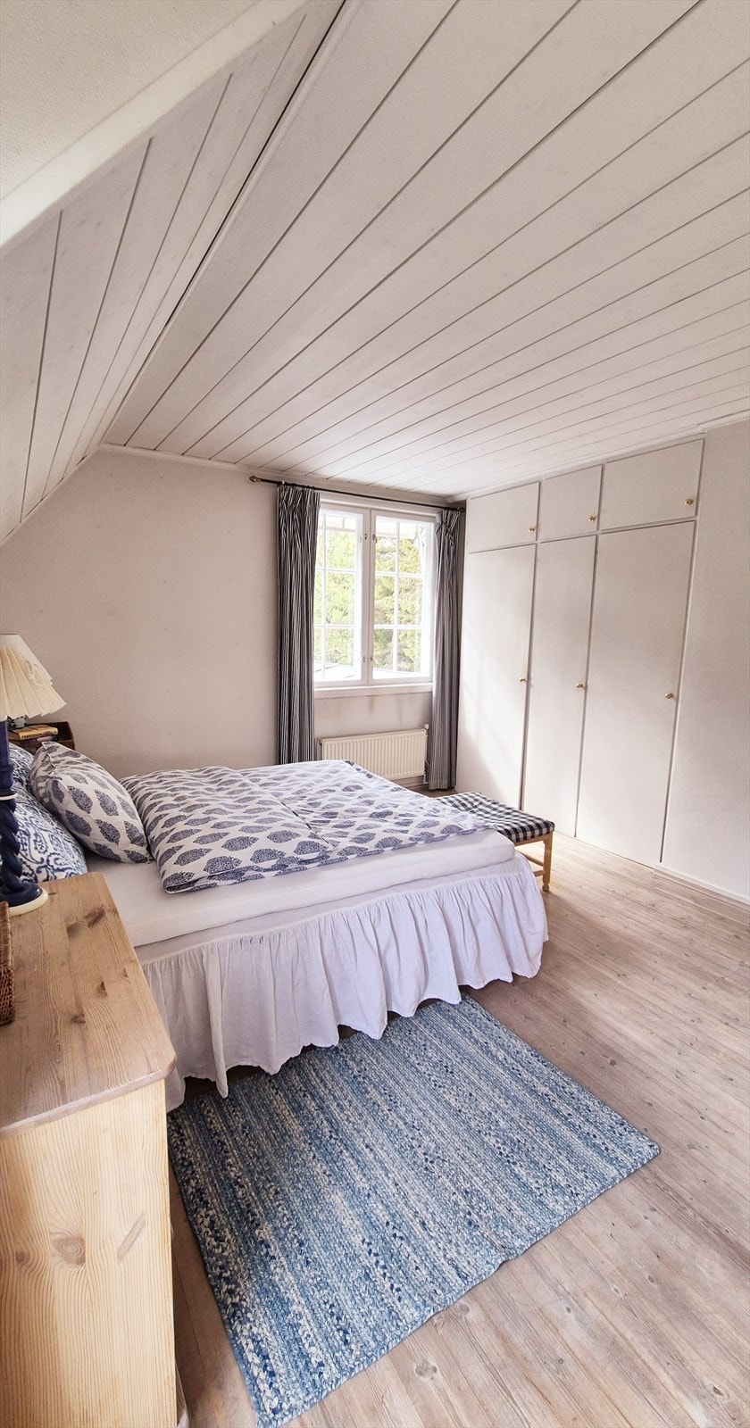 Lyst rom med vindu og plass til seng og nattbord. Galleribilde