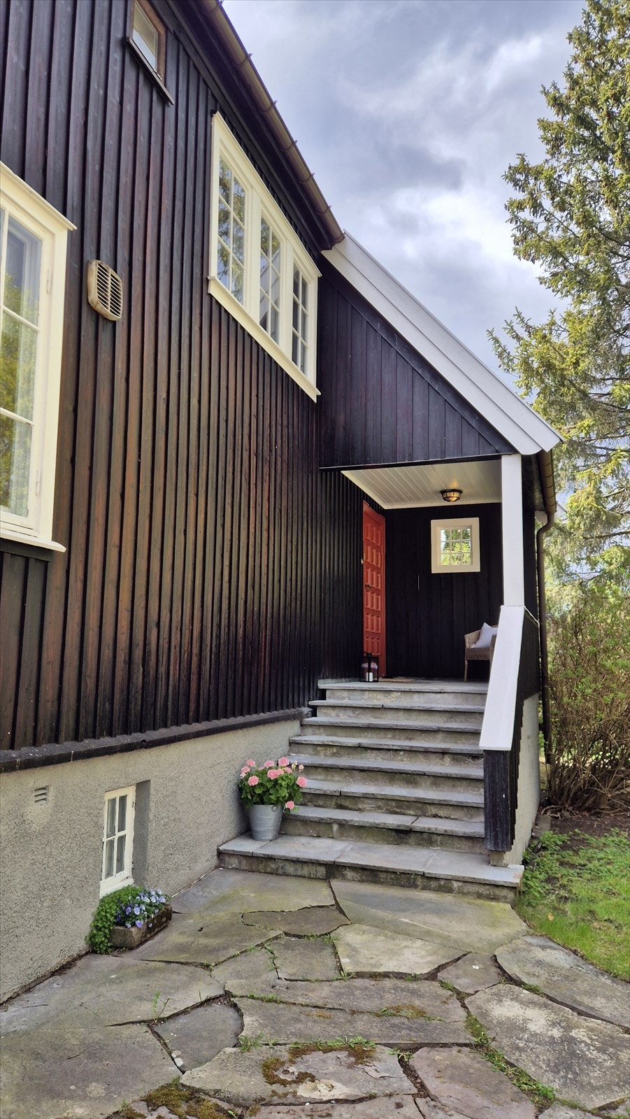 Tomten er opparbeidet med en flat til lett skrående jordtomt, omkranset av variert vegetasjon. Galleribilde