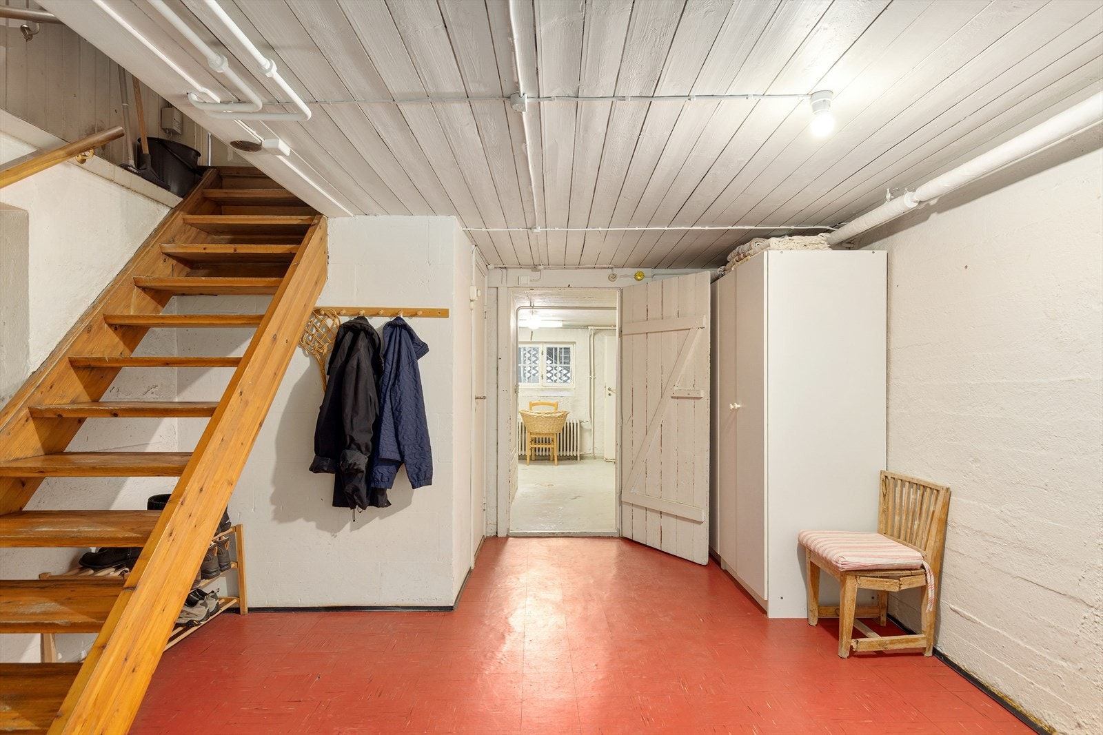 Kjelleretasje med betongvegger og malt gulvoverflate gir rom for oppbevaring og praktisk bruk. Galleribilde