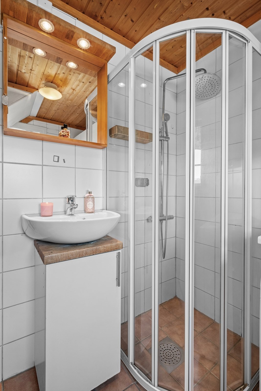 Badet er utstyrt med et toalett, gulvvarme, opplegg for vaskemaskin og tørketrommel, samt et dusjhjørne med regnfallsdusj. Galleribilde
