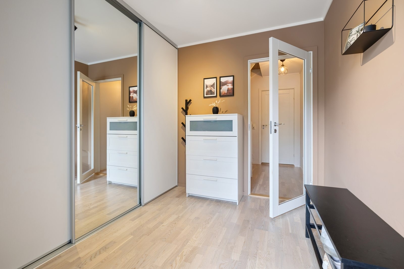 Romslig entré med skyvedørsgarderobe for effektiv oppbevaring av yttertøy og sko. Galleribilde