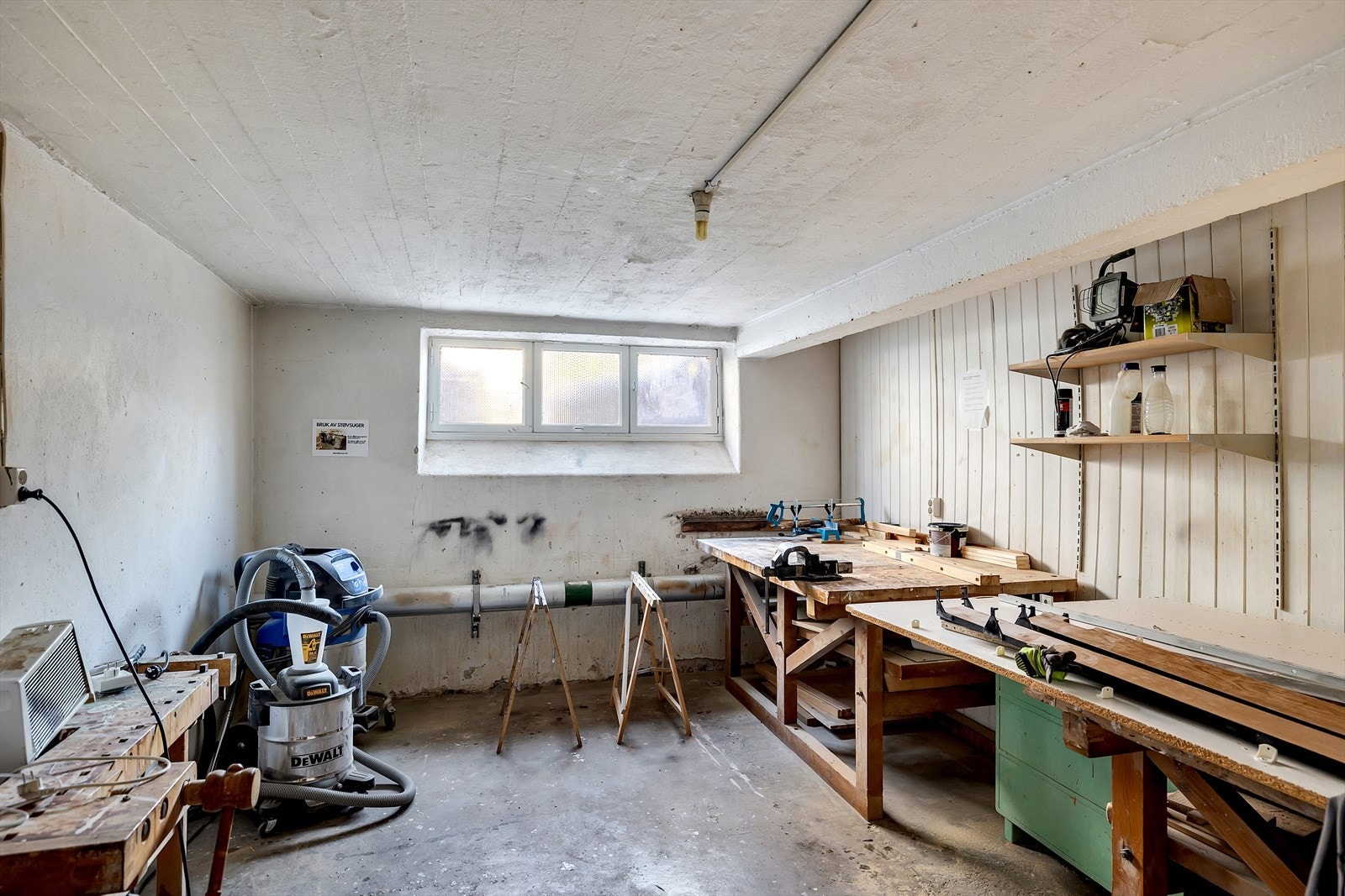 Praktisk verksted med arbeidsbenk og oppbevaringshyller. Galleribilde