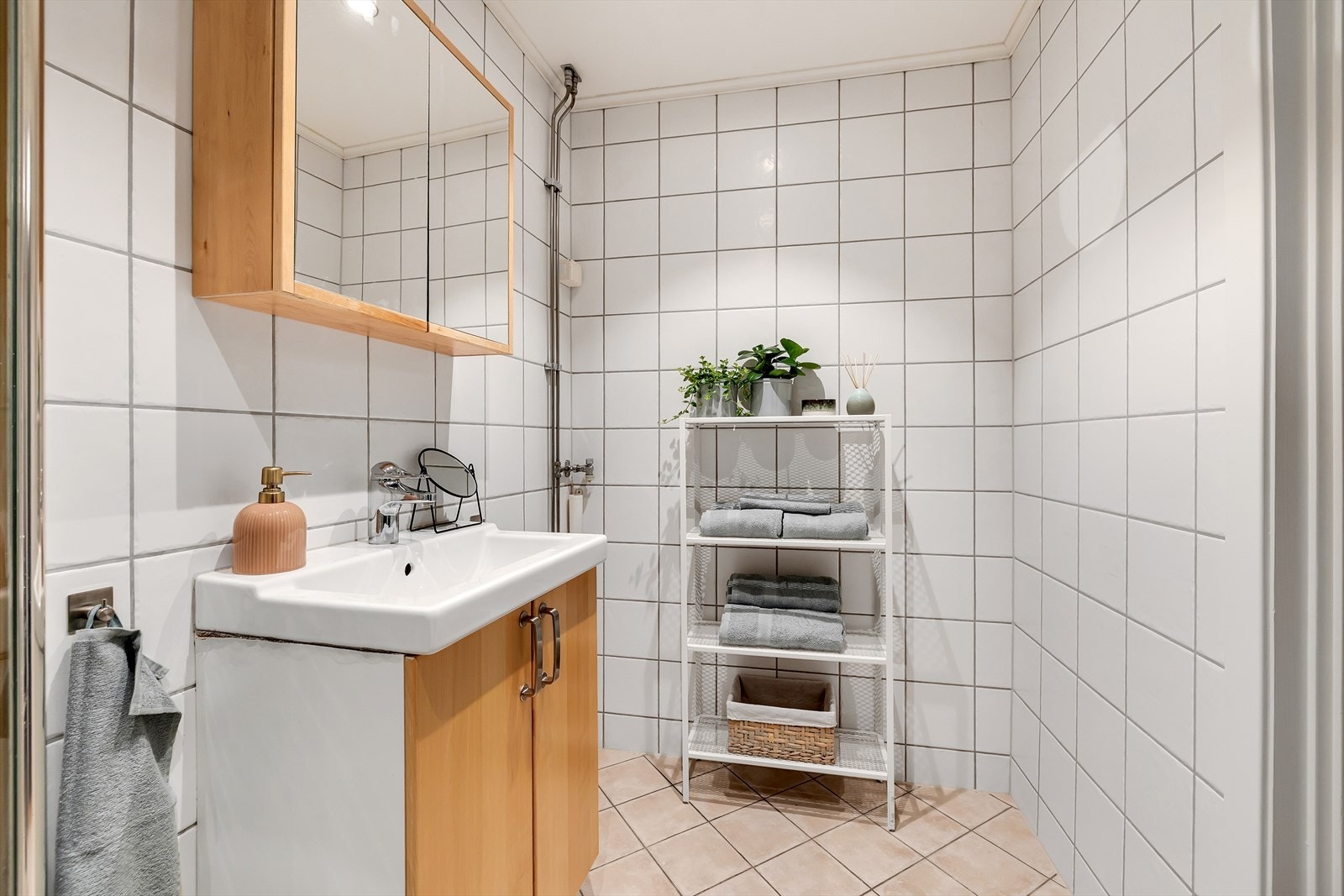 Badet er utstyrt med veggmontert wc, servant med underskap, speilskap og veggmonterte dusjdører. Det er opplegg for vaskemaskin. Galleribilde