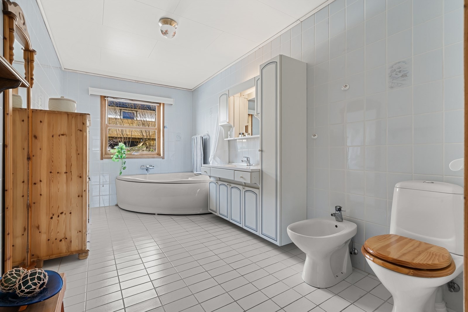 Badet i 1. etasje/Hovedetasje har fliser på vegger og gulv samt sanitærutstyr som badekar, bidet, servant og toalett. Galleribilde