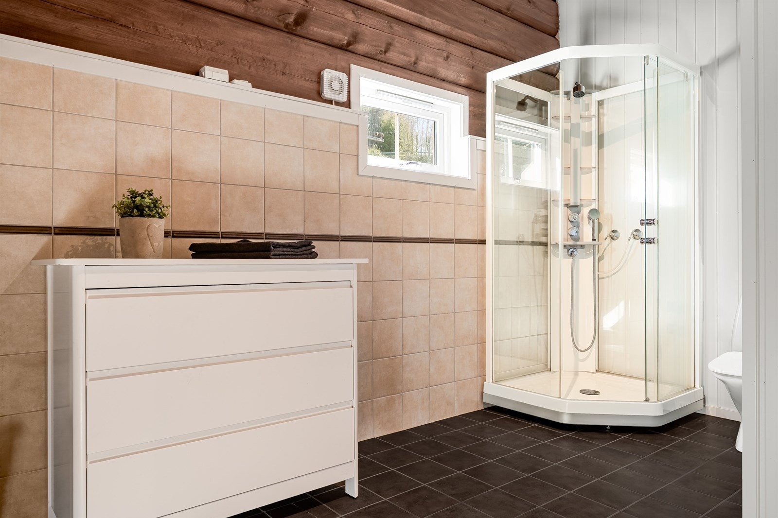 Badet er utsyrt med dusjkabinett, mekanisk avtrekk, servantskap og wc, samt gulvvarme. Galleribilde