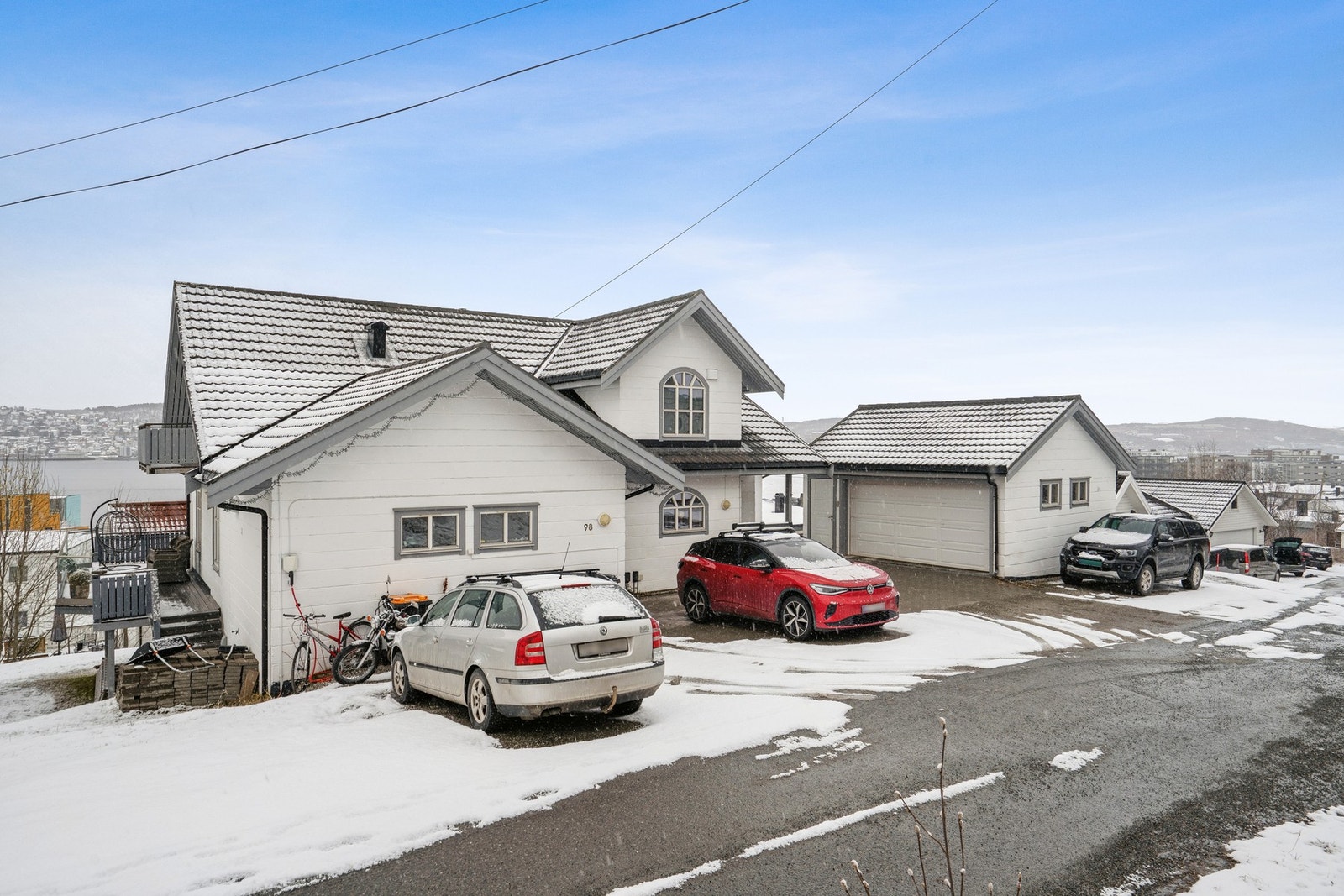 Delvis brosteinsbelagt gårdsplass med parkering og adkomst til garasje. Galleribilde