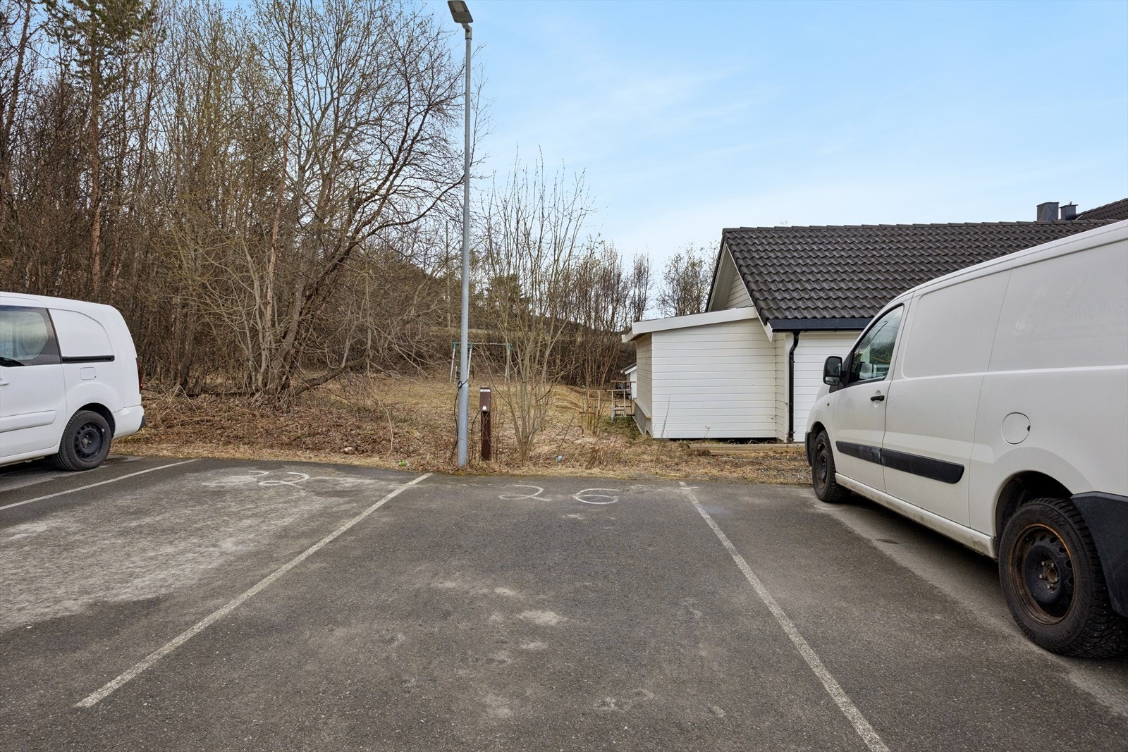 Fast parkeringsplass på felles, asfaltert område. Galleribilde