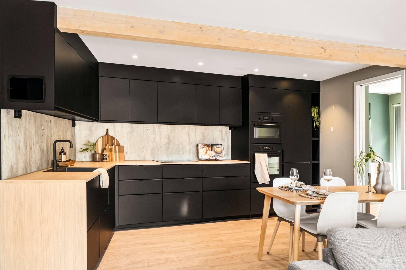 Det moderne kjøkkenet fremstår tidløst og elegant med rene linjer, integrerte løsninger og gjennomgående materialvalg. Spiseplassen ligger naturlig tilknyttet kjøkkenet. Galleribilde